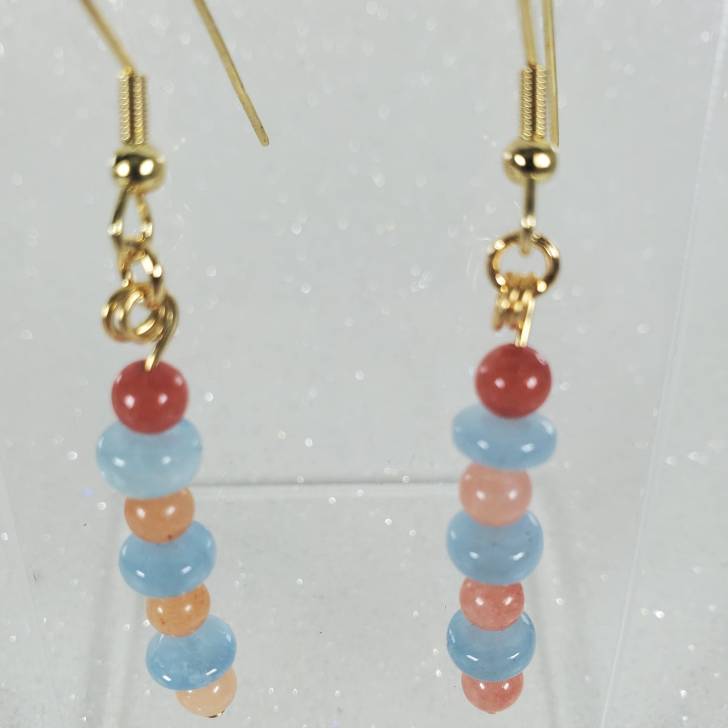 Pair of beaded earrings with gold hooks on a clear background