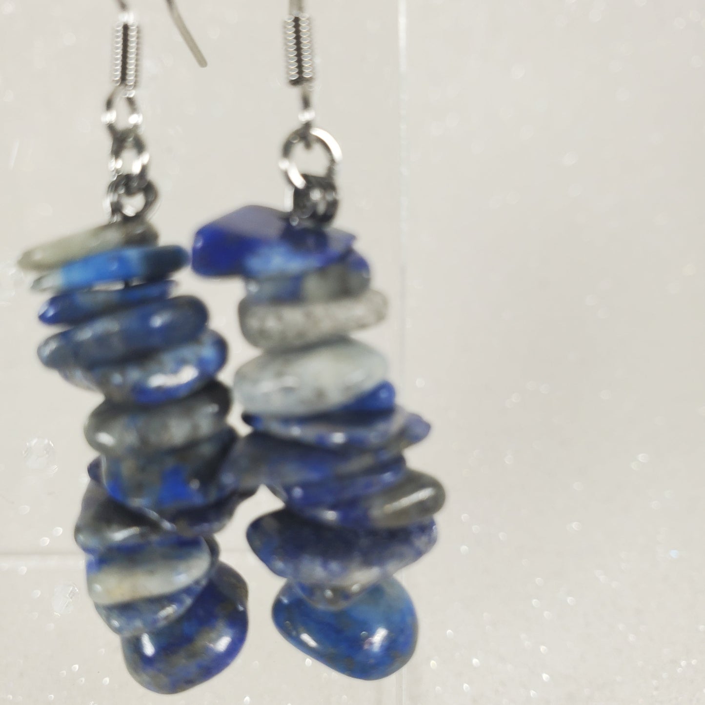 Pair of blue and gray beaded earrings on a white background