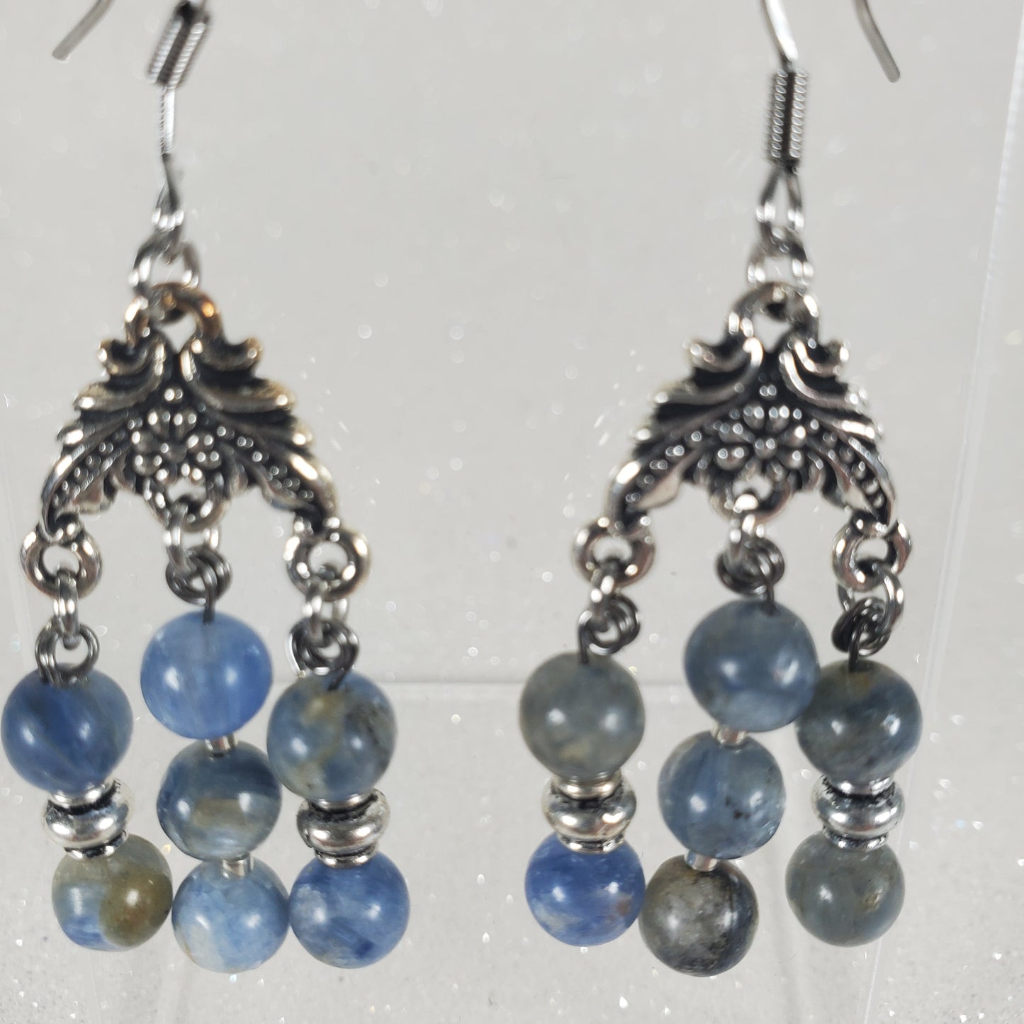 Pair of blue beaded earrings with silver hooks on a white background