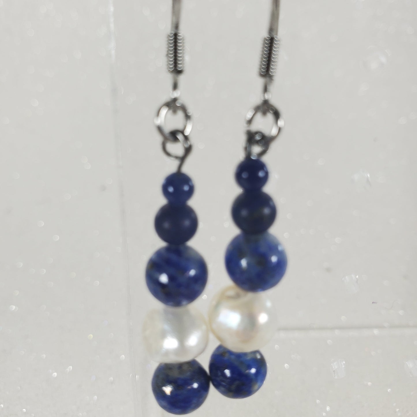 Pair of blue and white beaded earrings on a light gray background
