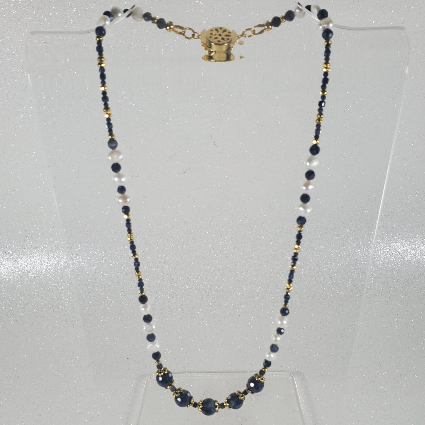 Necklace with beads and a clasp on a light gray background