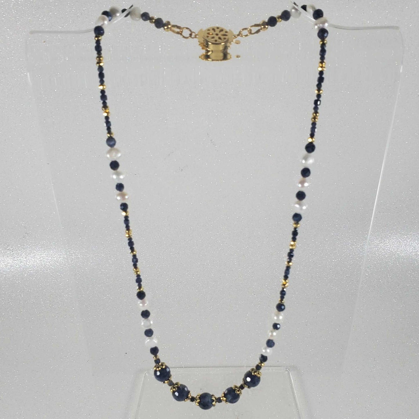 Elegant gemstone necklace with sapphire, freshwater pearls, brass, and gold hematite accents on an 18-inch chain with vintage clasp
