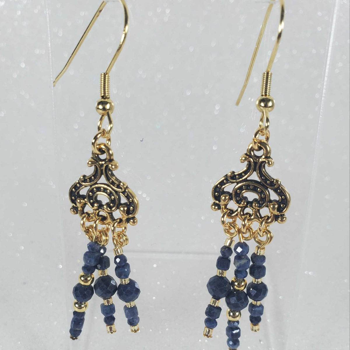 Gemstone Earrings with deep blue faceted beads, gold-tone hooks and ornate filigree chandelier drops with dangling strands.