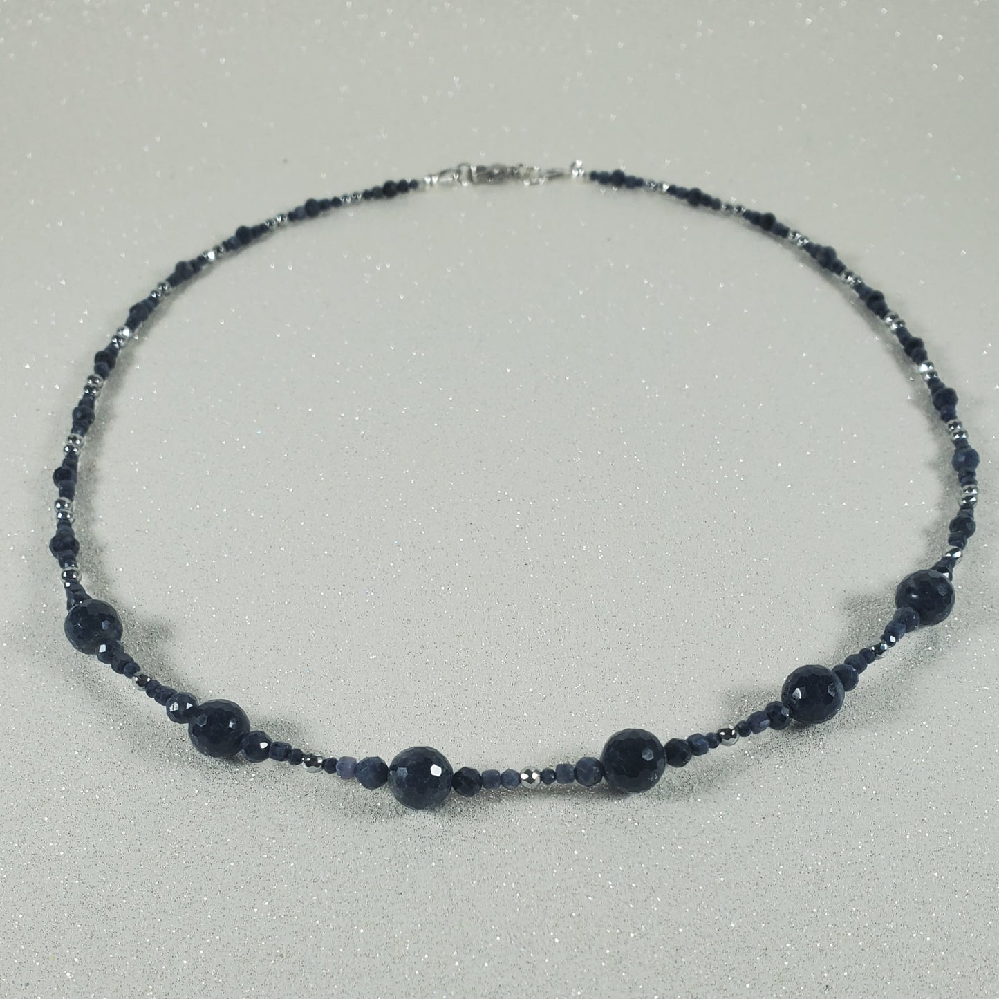 Necklace with dark blue beads on a gray background