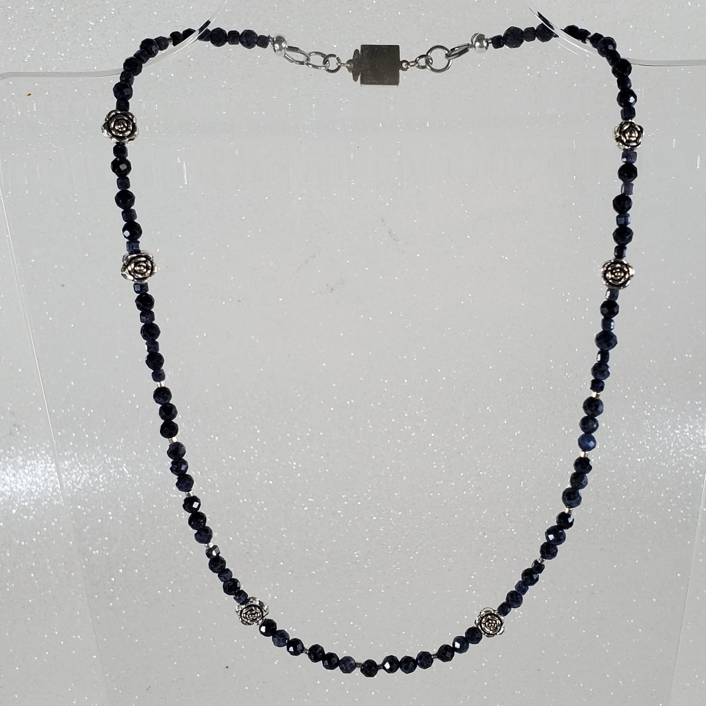 Necklace with blue beads and silver clasp on a white background