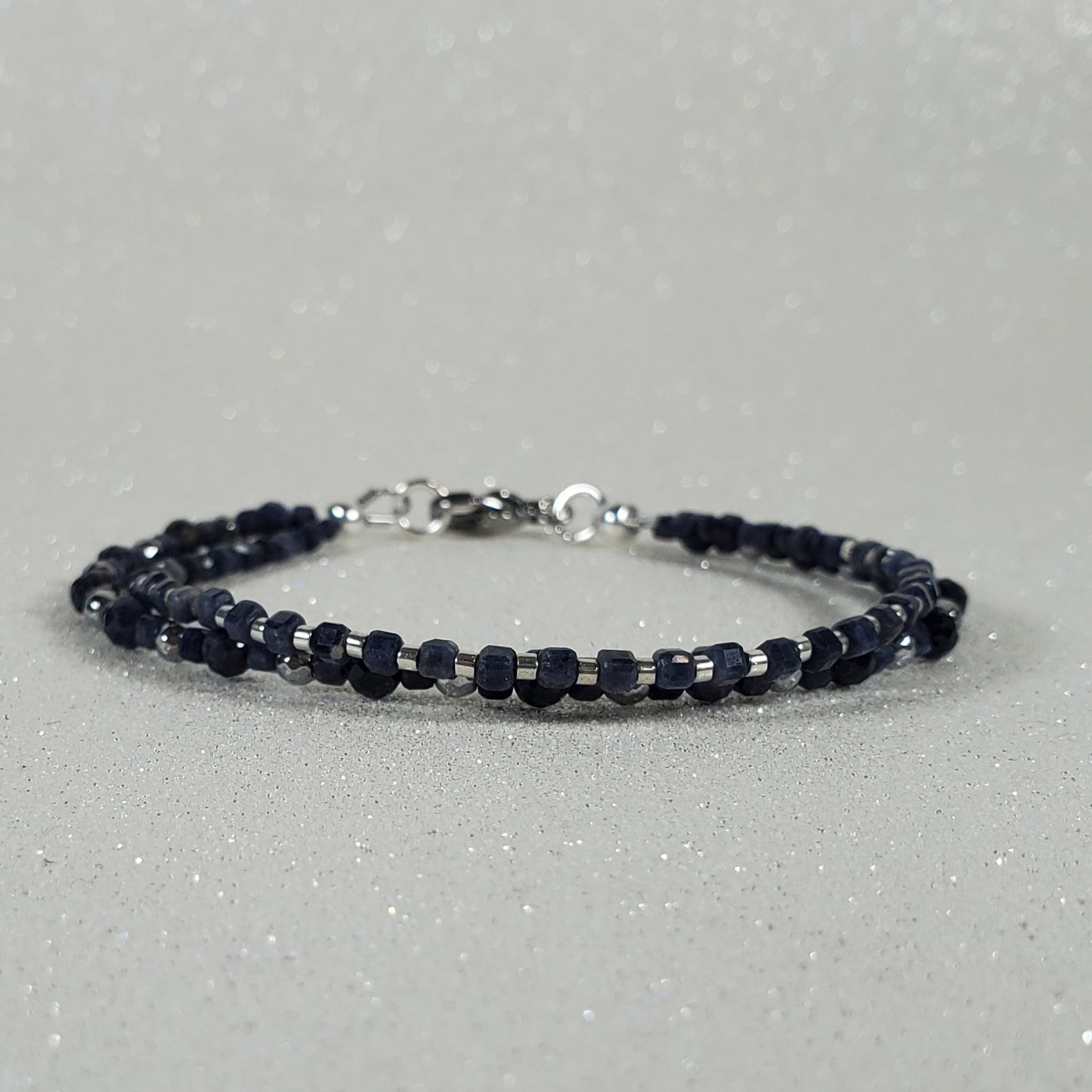 Navy blue beaded bracelet on a gray background