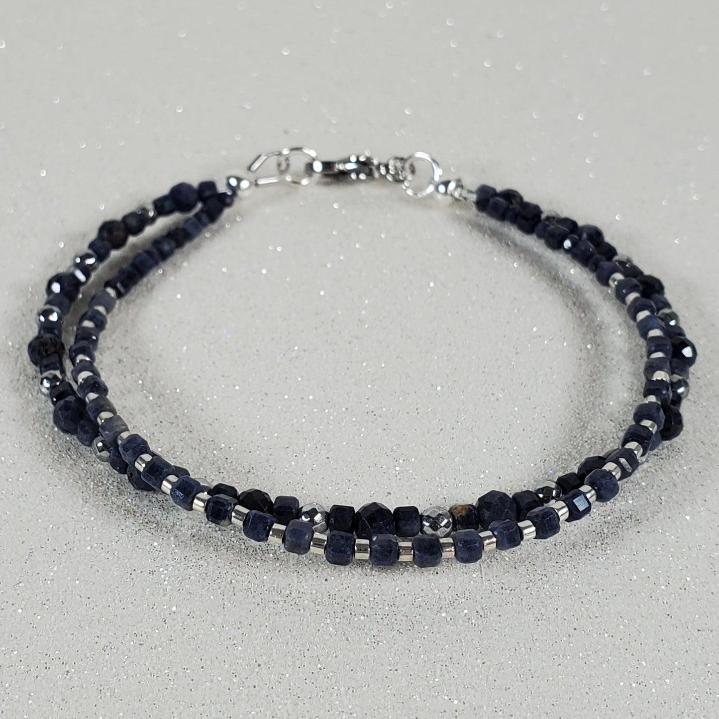 Blue beaded bracelet on a gray background
