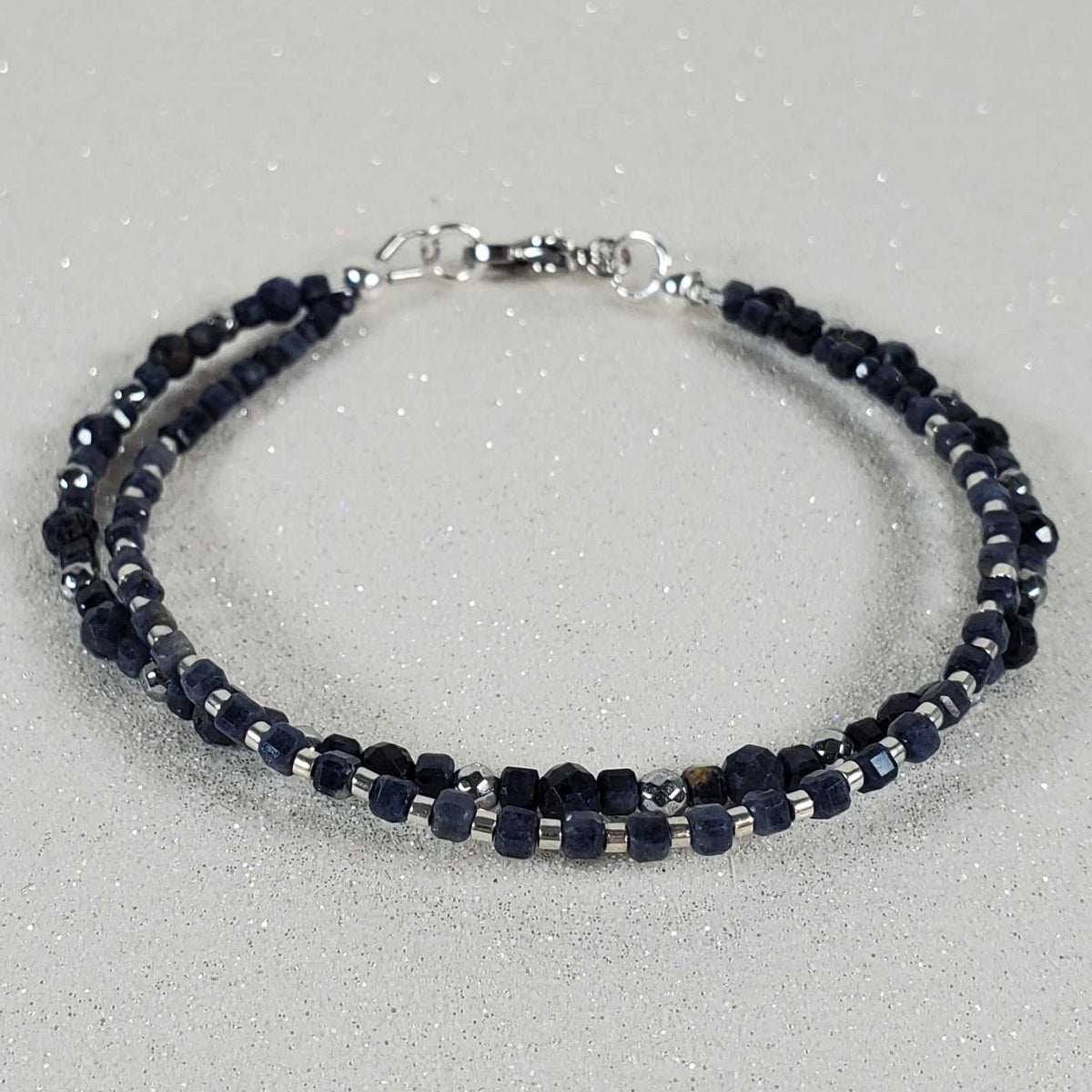 Gemstone Bracelet with two strands of deep navy faceted beads, silver-tone accents and a lobster clasp.