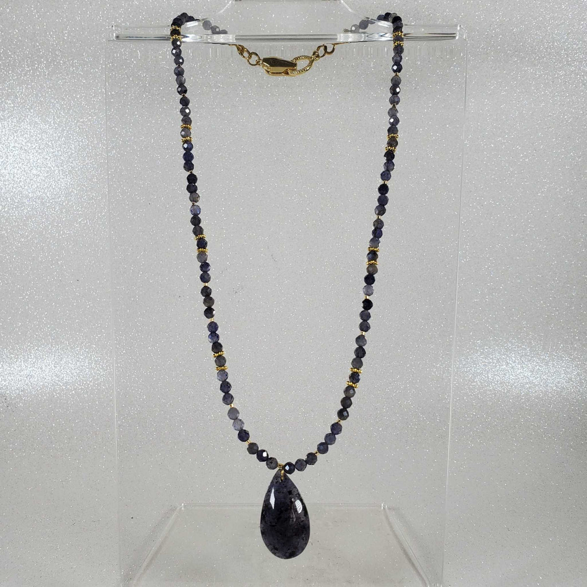 Gemstone Necklace with dark violet-blue faceted beads, gold-tone accents, and a matching teardrop pendant.