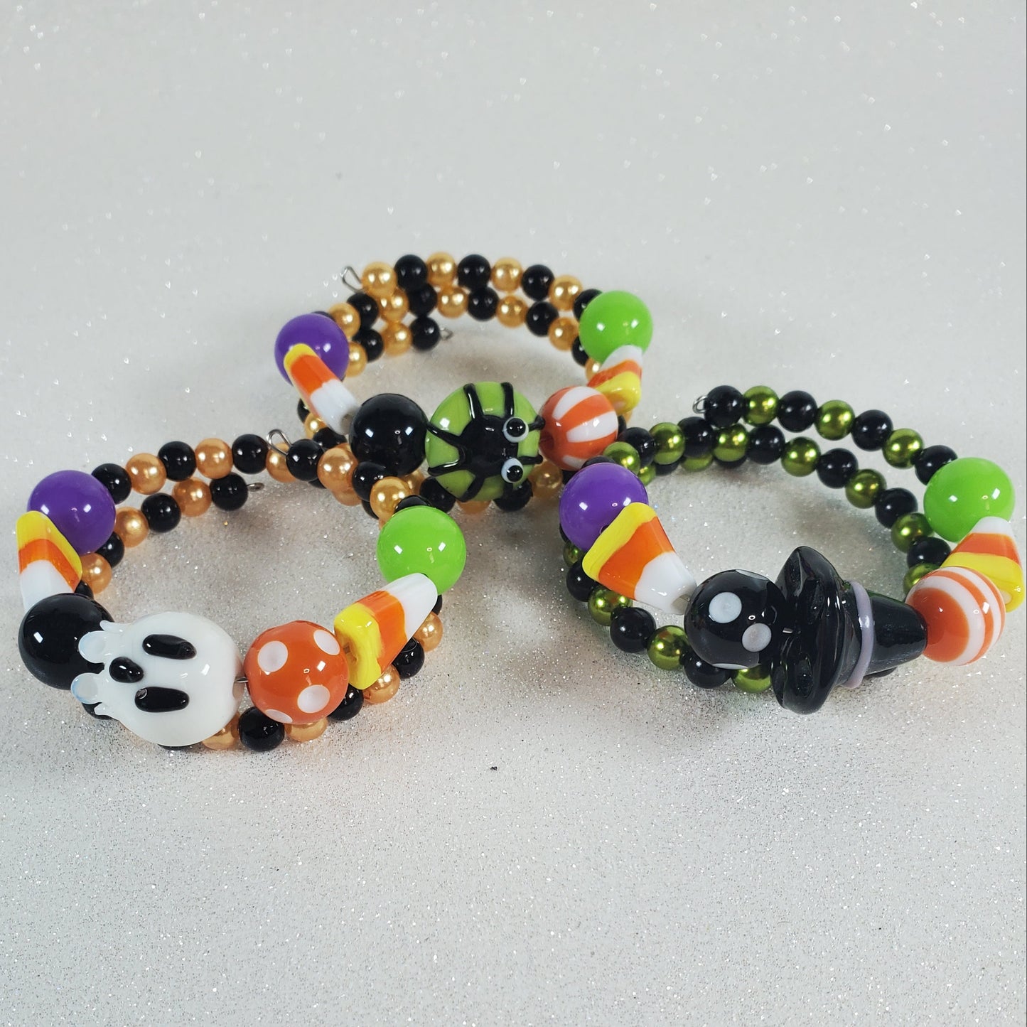 Halloween-themed beaded bracelets with colorful beads on a gray background
