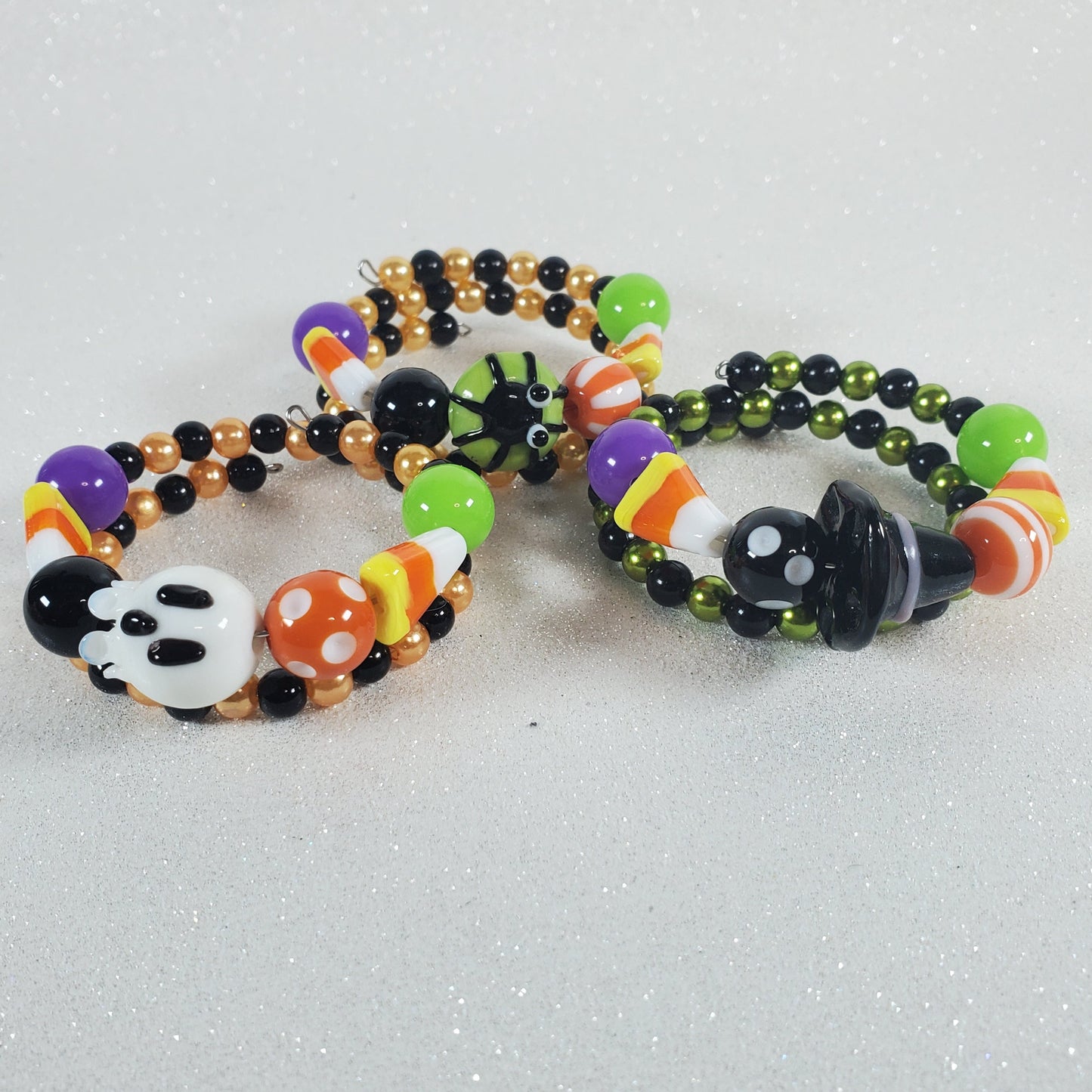Three Halloween-themed beaded bracelets on a light gray background