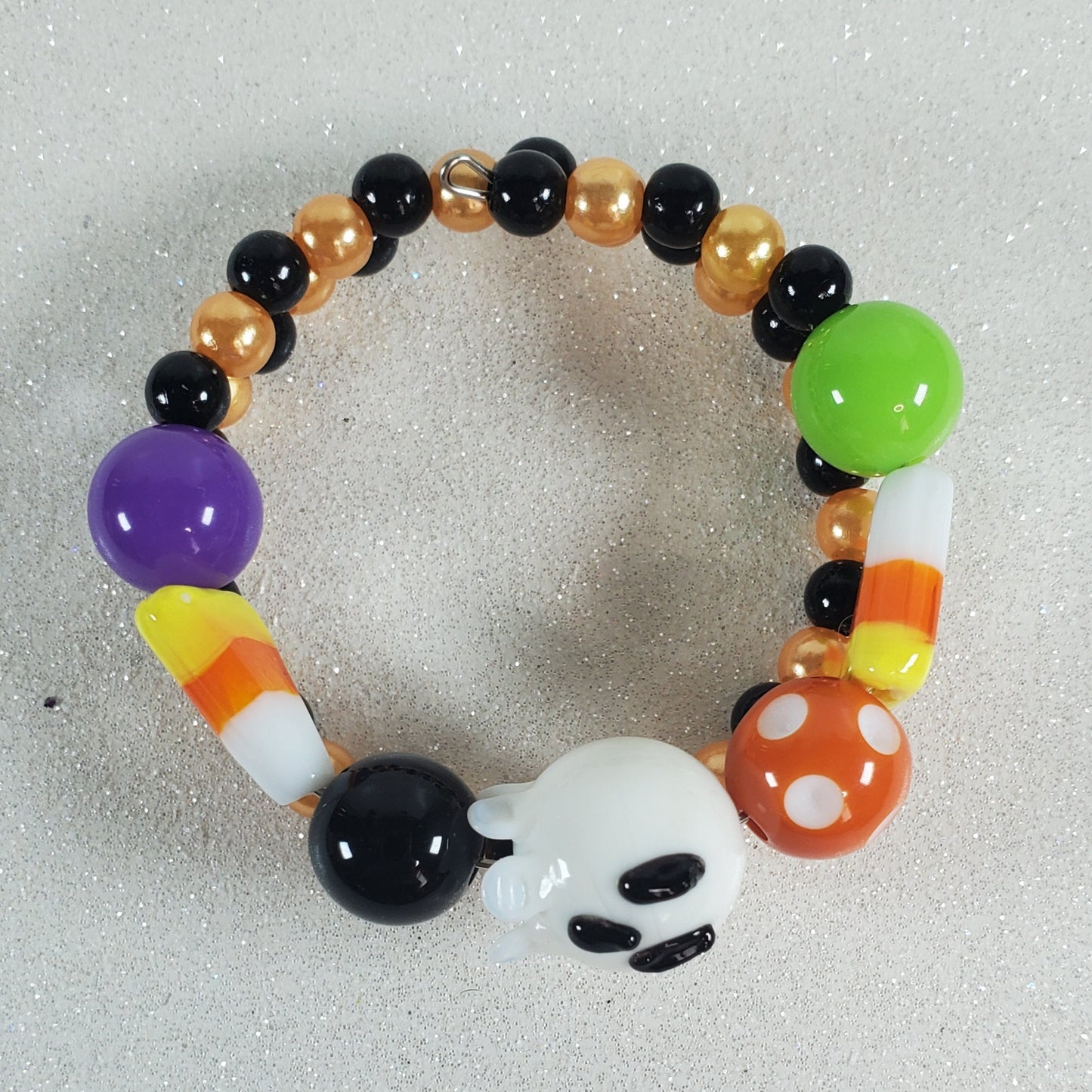 Colorful beaded bracelet with ghost and candy corn design on a light gray background