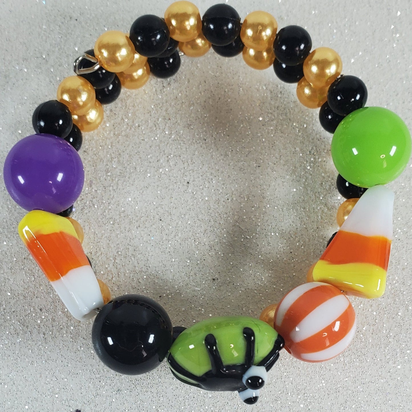 Colorful beaded bracelet with Halloween-themed beads on a light gray background