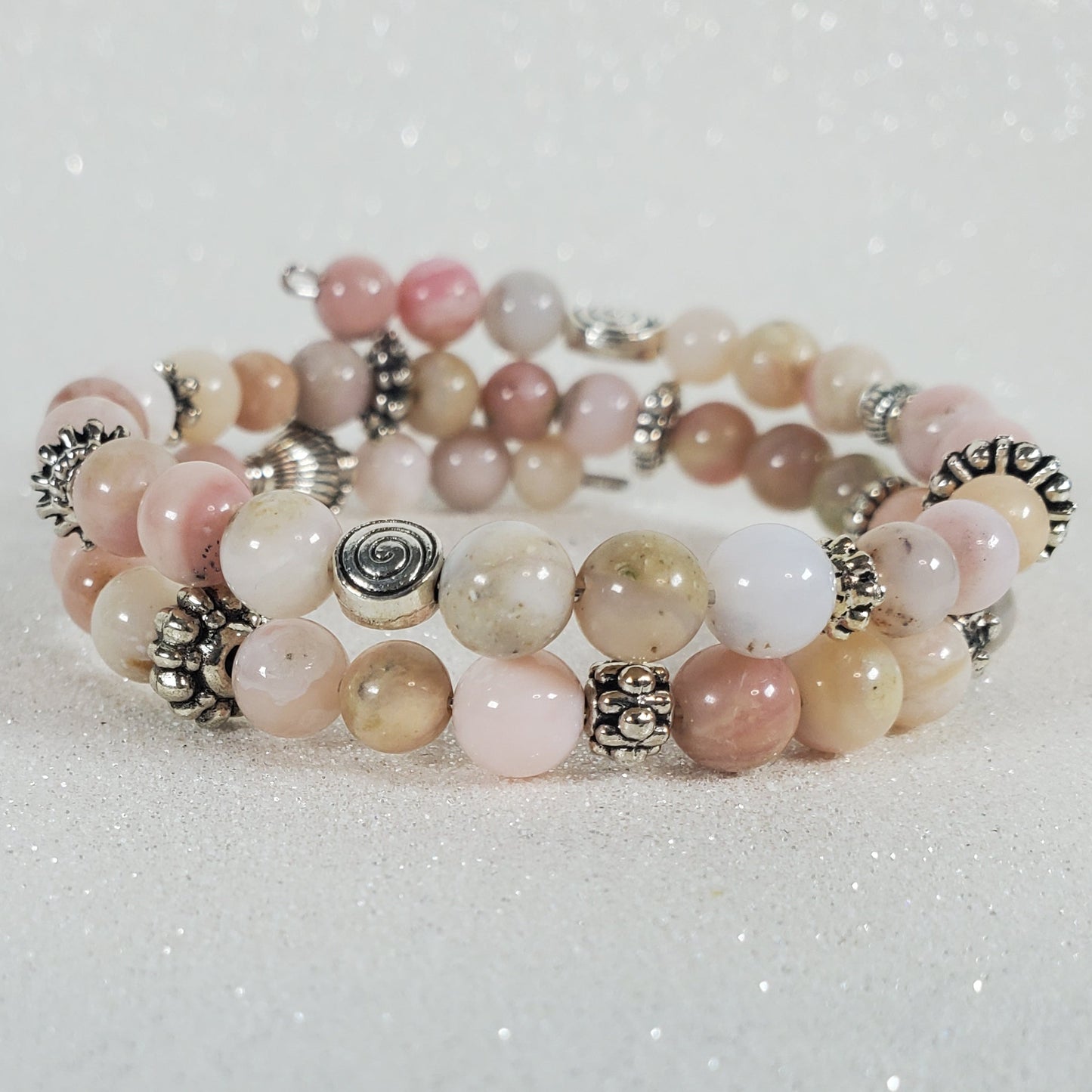 Multistrand beaded bracelet with pink and white beads on a light gray background