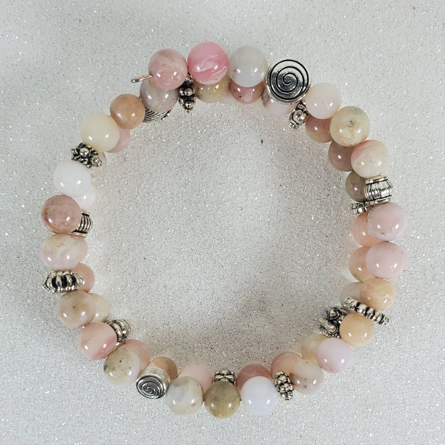 Beaded bracelet with pink and white beads on a light gray background