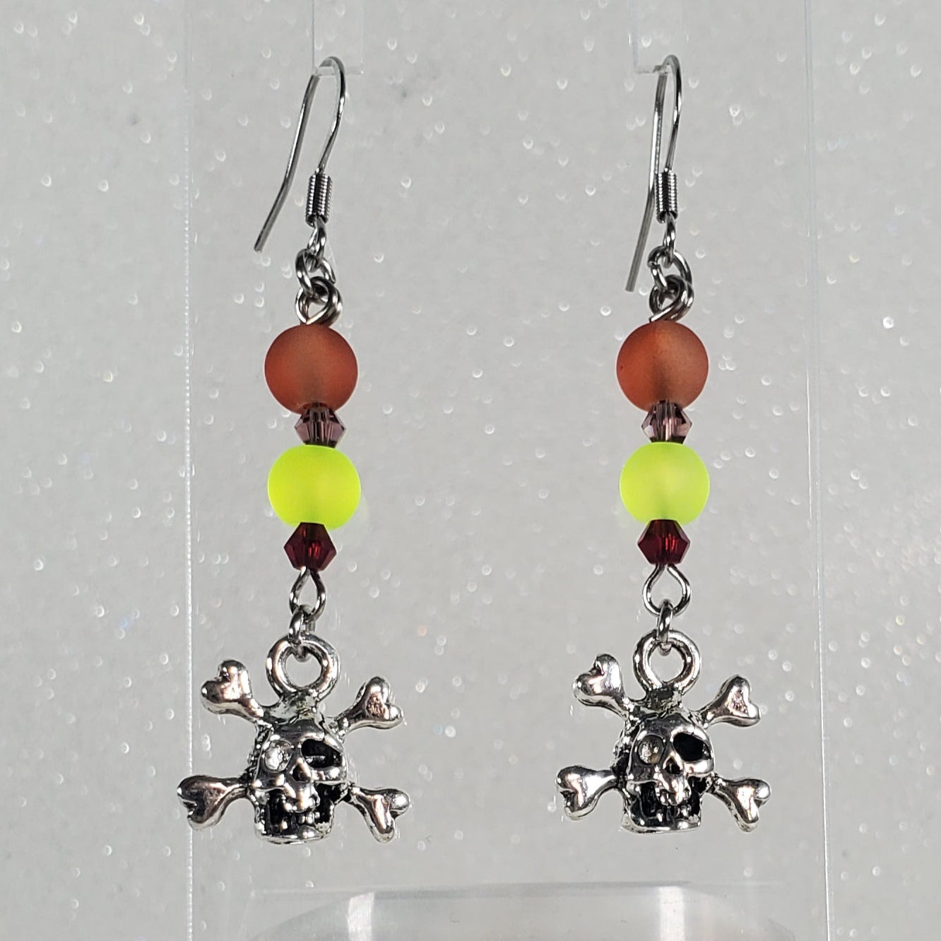 Earrings with beads in a clear container on a white background