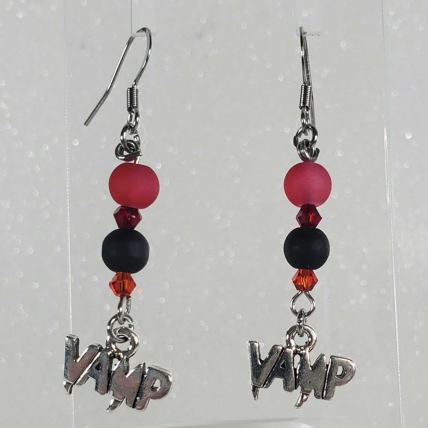 Pair of earrings with beads and charms on a white background