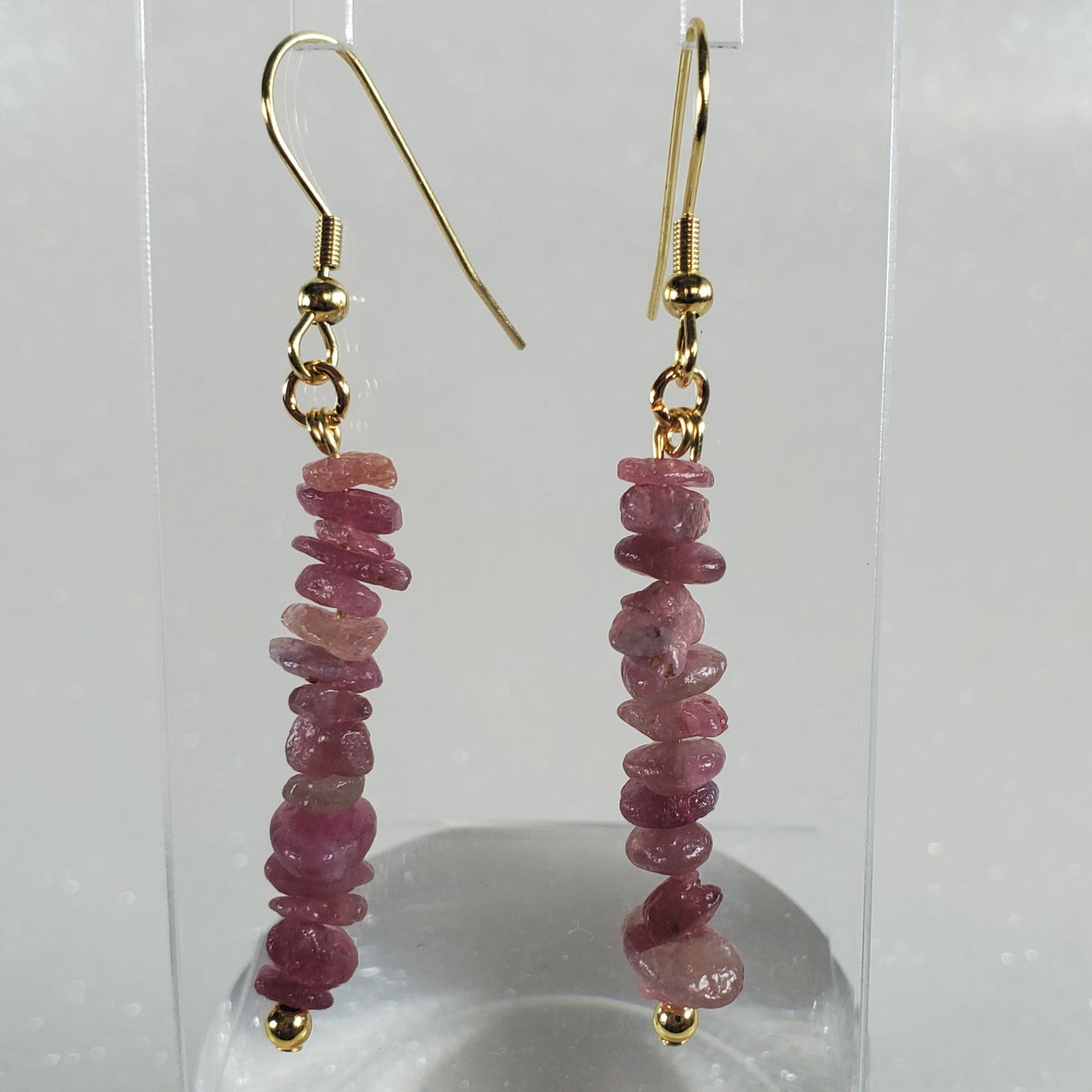 Pink beaded earrings on gold hooks displayed against a white background