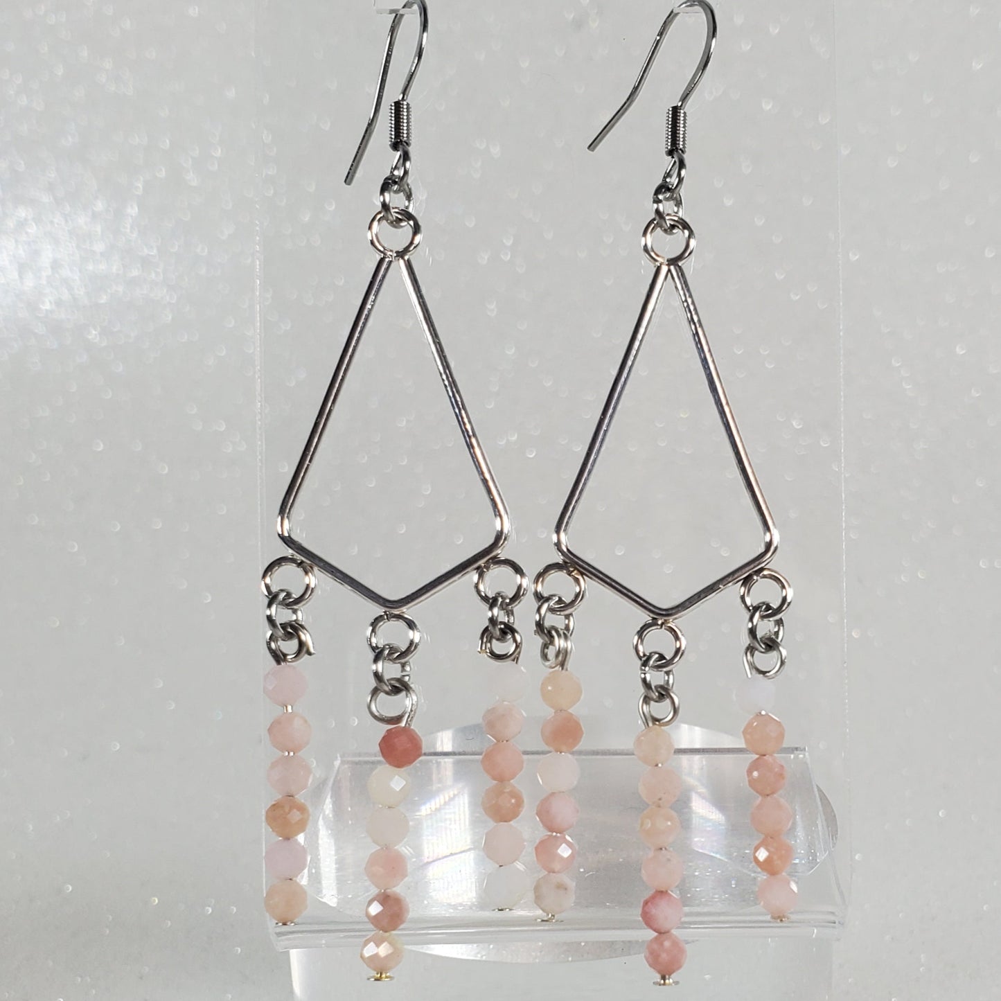 Set of earrings on a clear stand against a white background