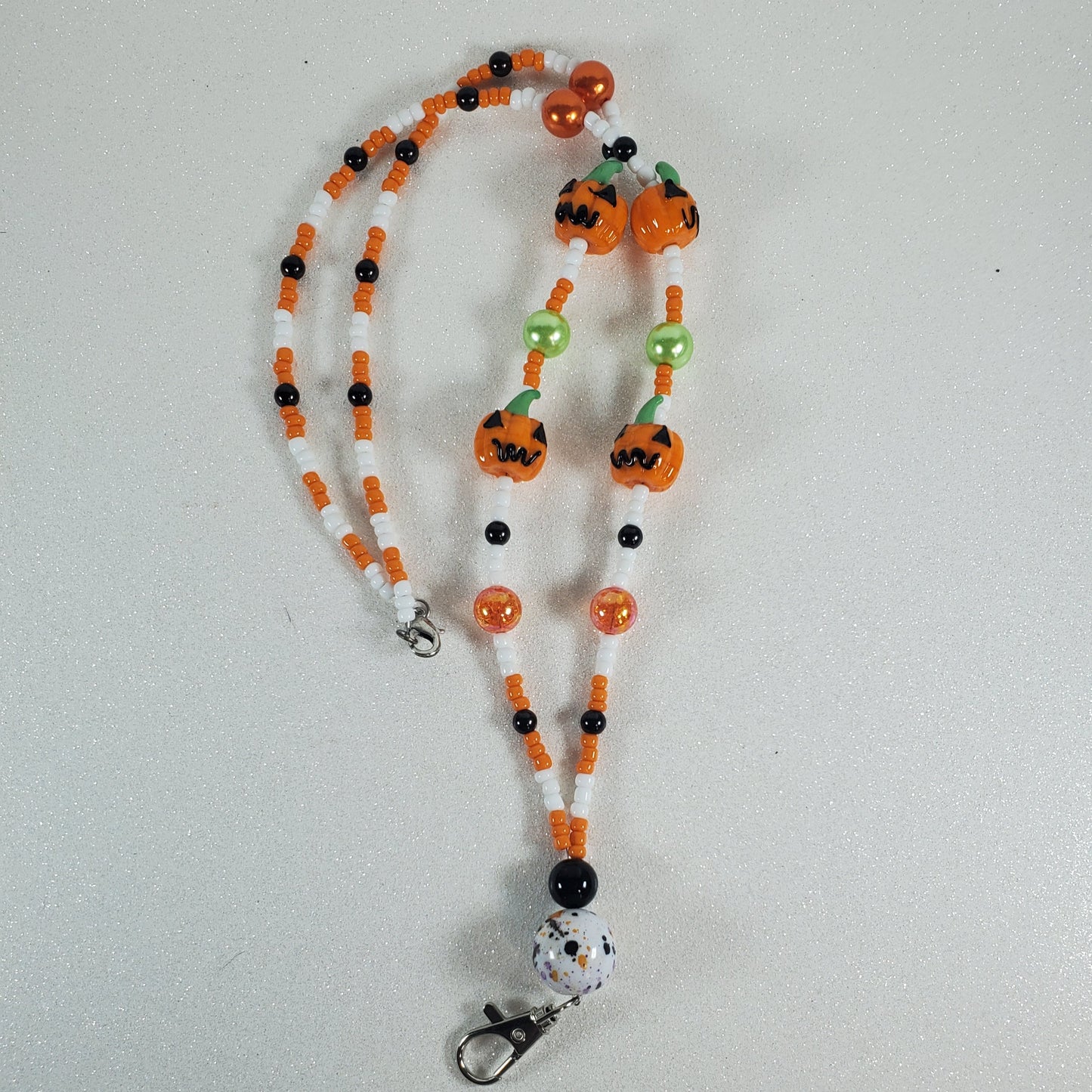 Beaded lanyard with pumpkin decorations on a white background