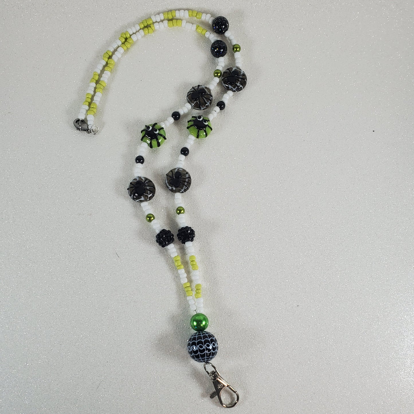 Beaded lanyard with black and green beads on a white background