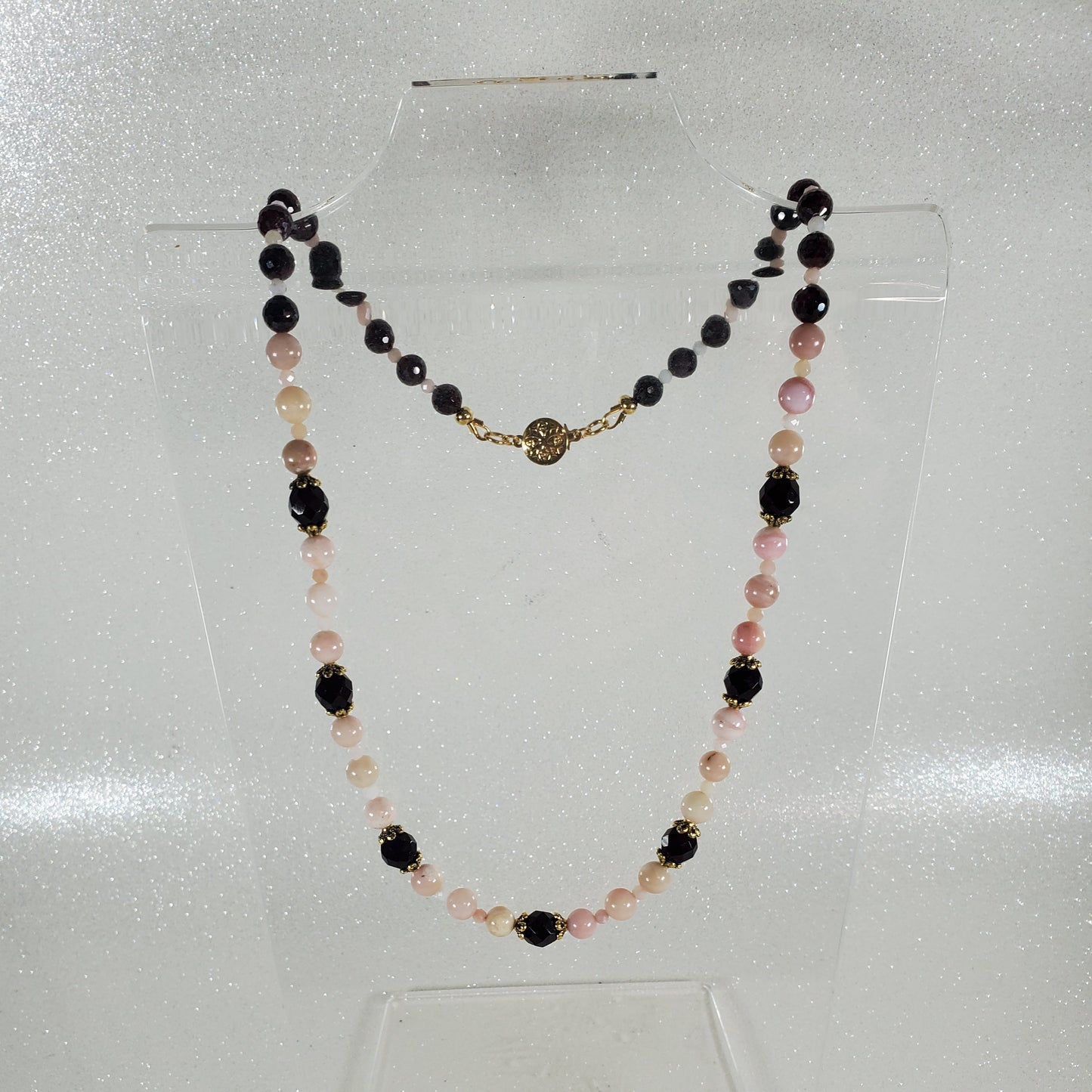 Necklace with deep red and pink beads on a white background