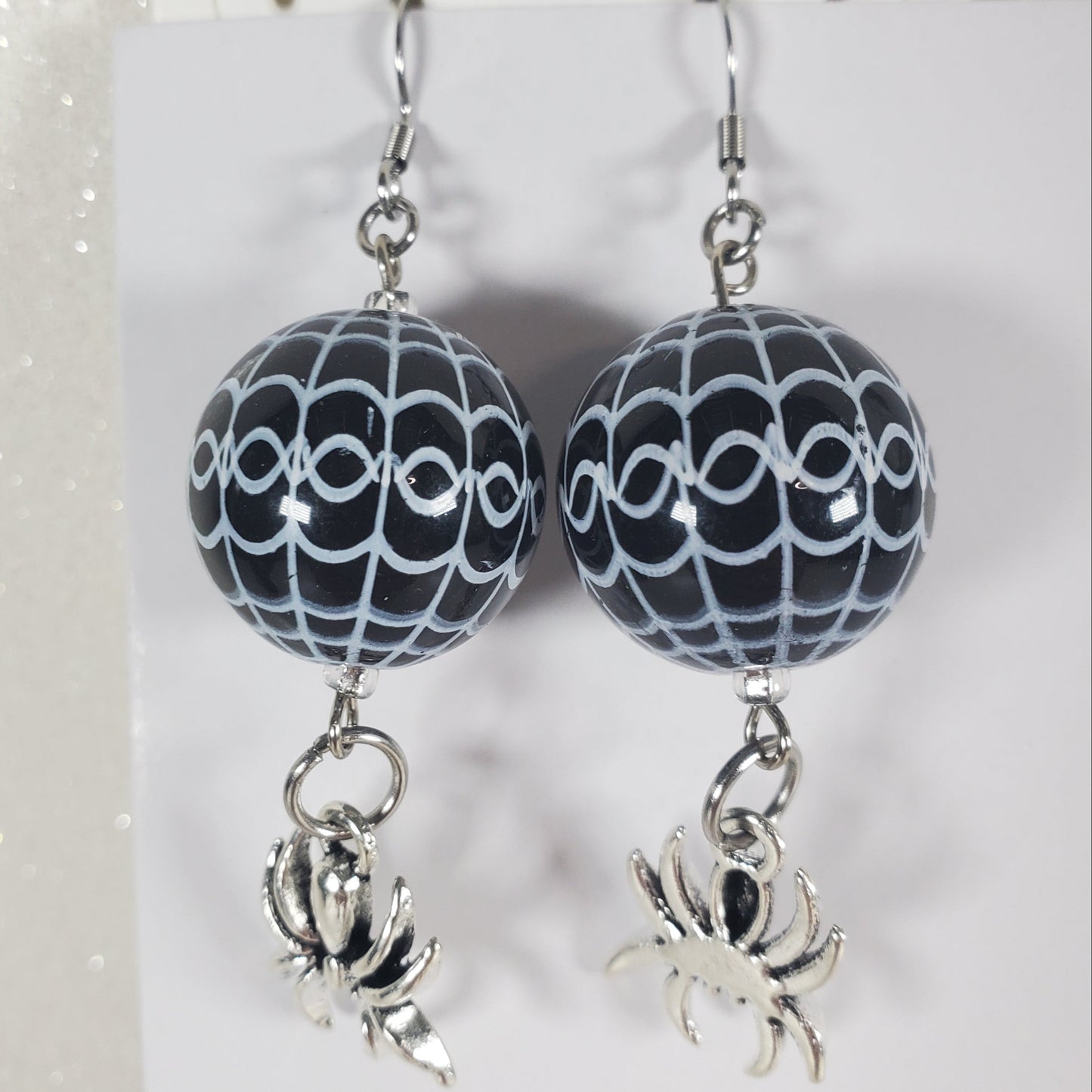Pair of earrings with black and white patterned beads on a white background