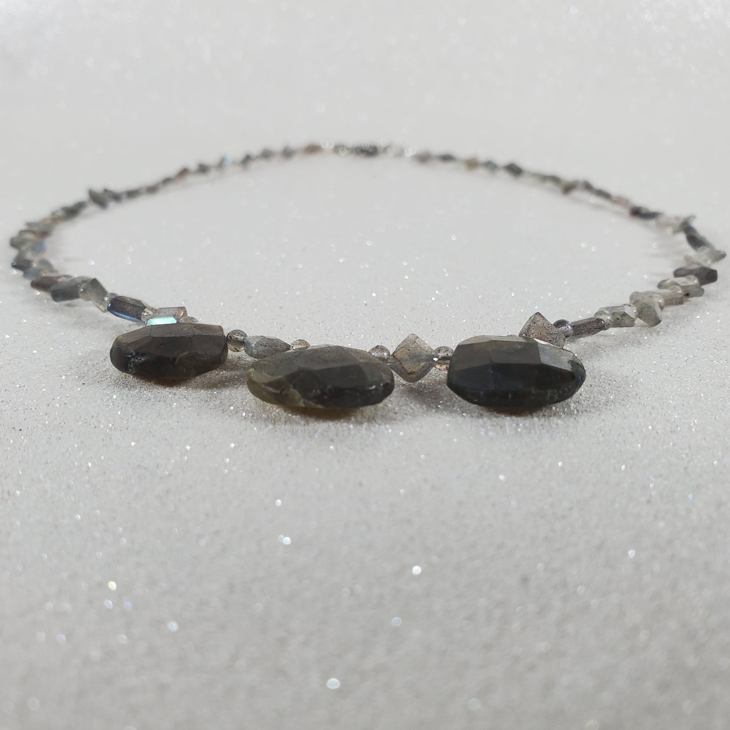 Necklace with dark beads on a light gray background