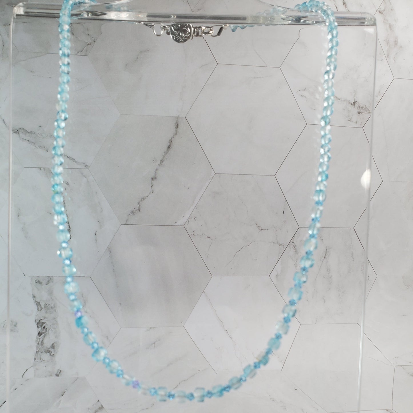 Blue Topaz necklace on marble tile