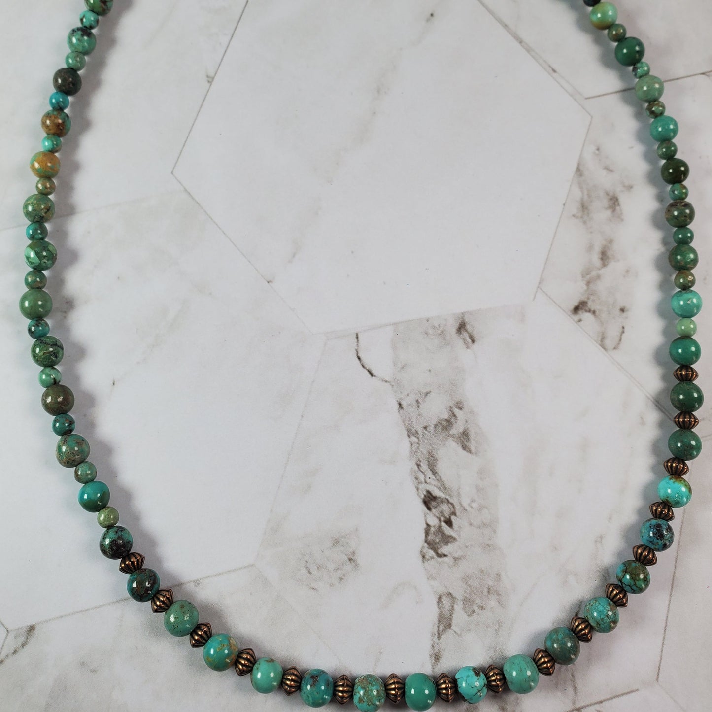 Necklace with multicolored beads on a marble surface