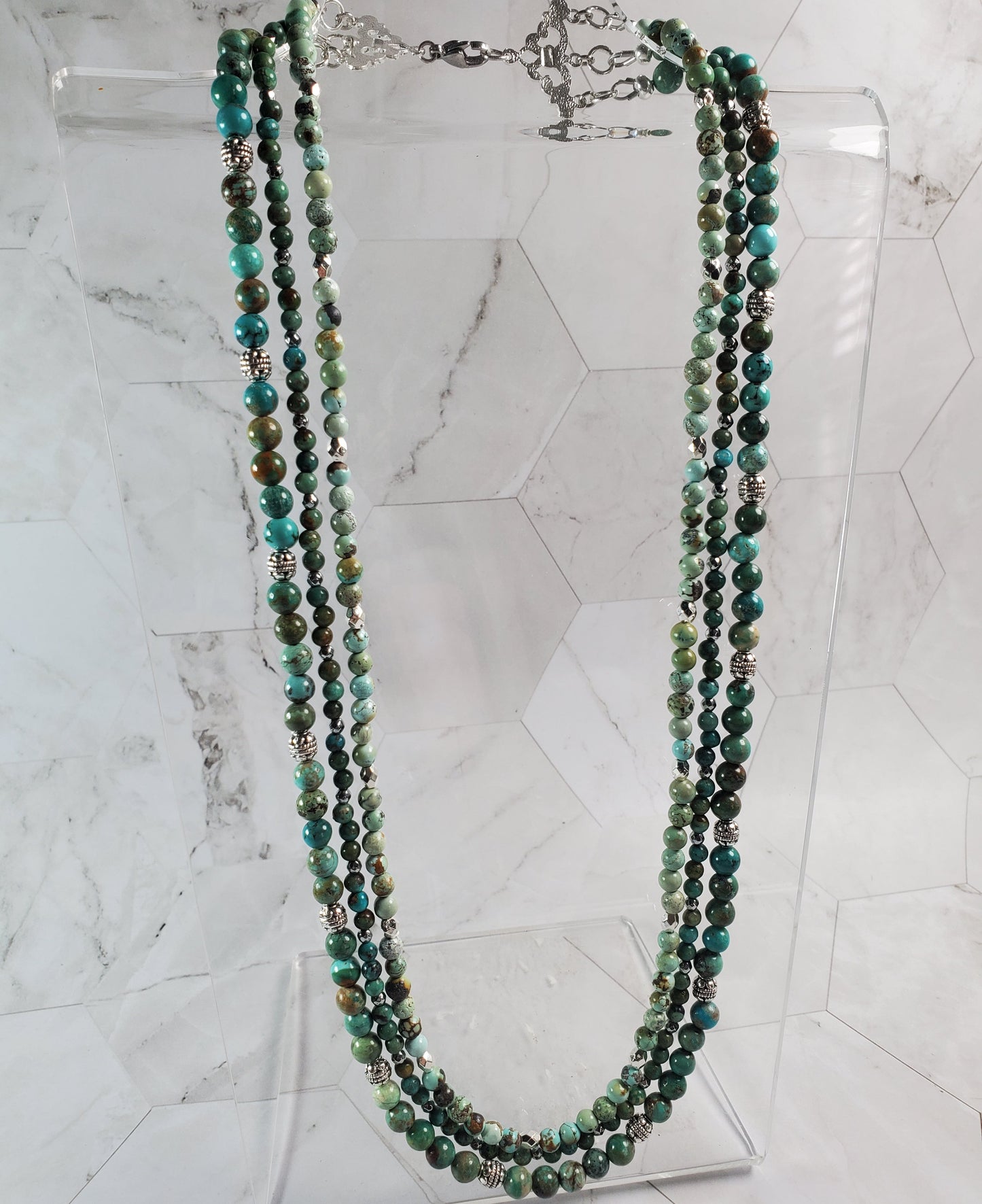 Green beaded necklace on a marble surface