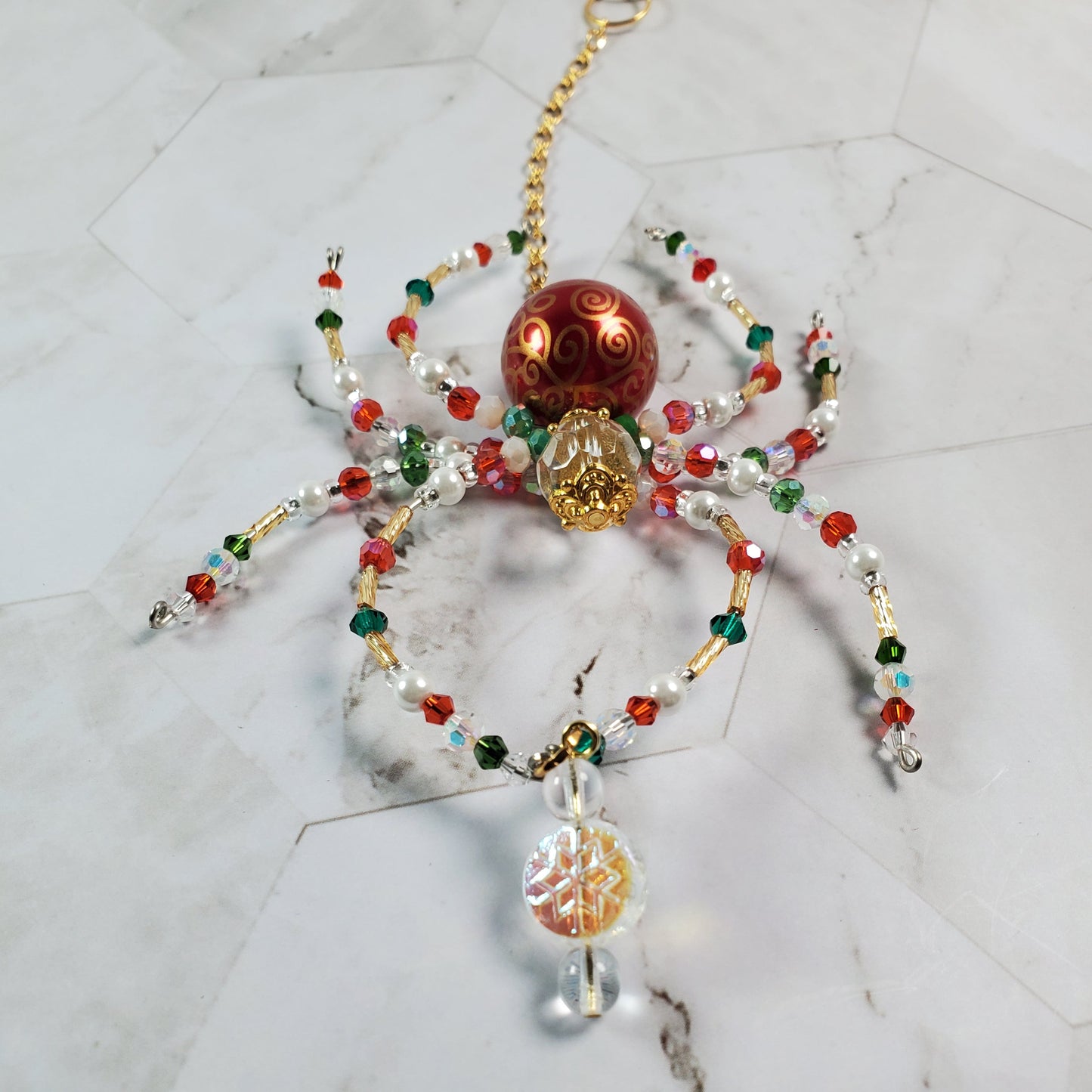 Decorative spider made of beads on a marble surface