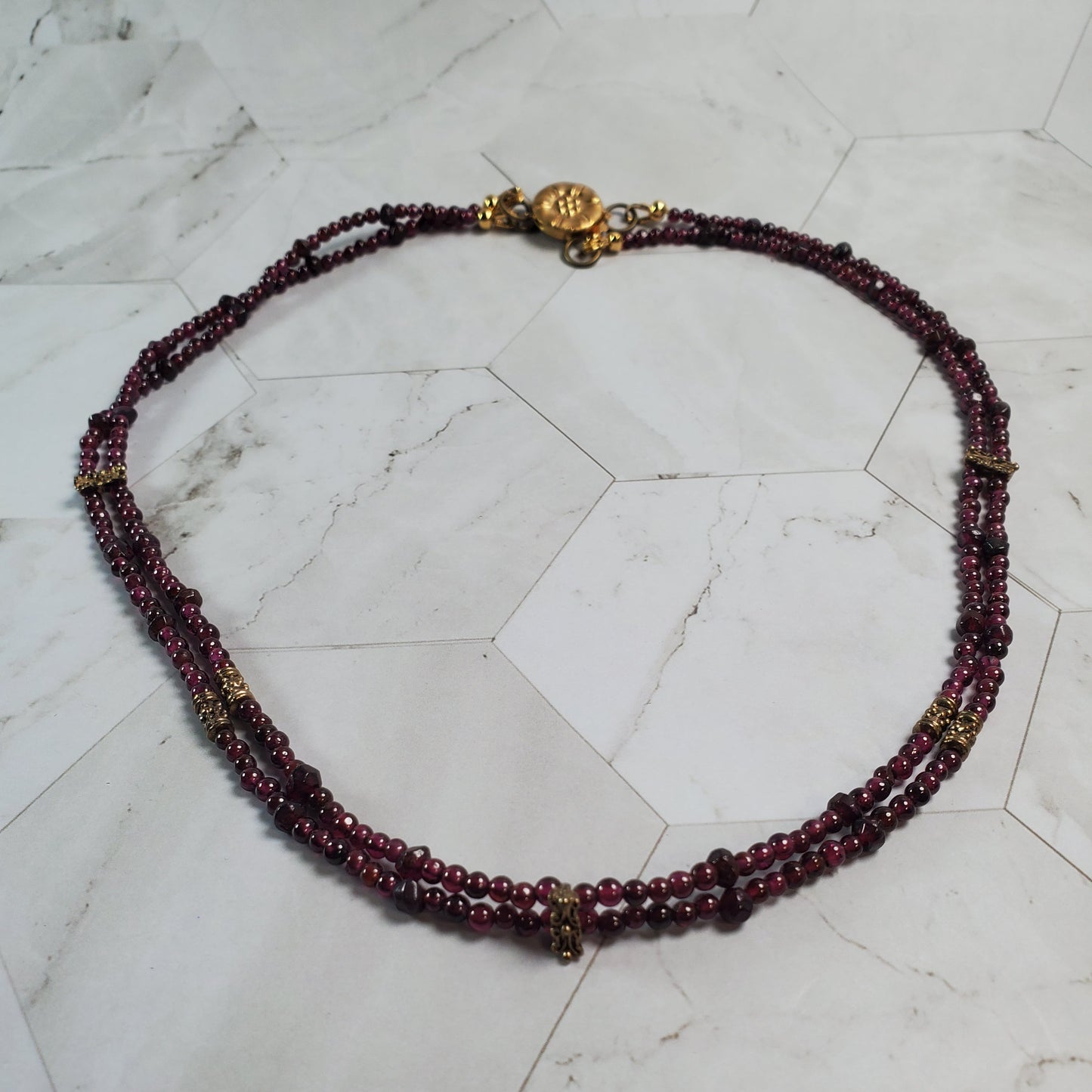 Beaded necklace with gold accents on a marble surface