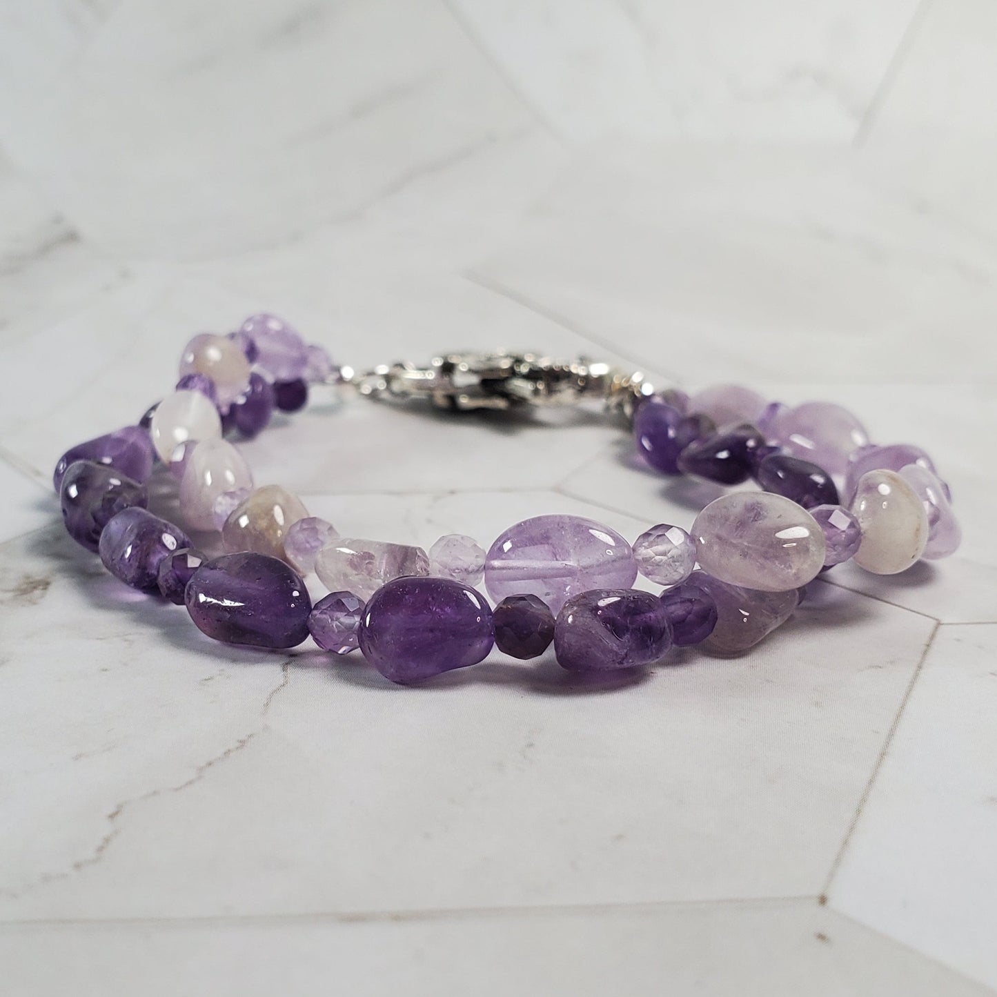 Purple beaded bracelet on a marble surface