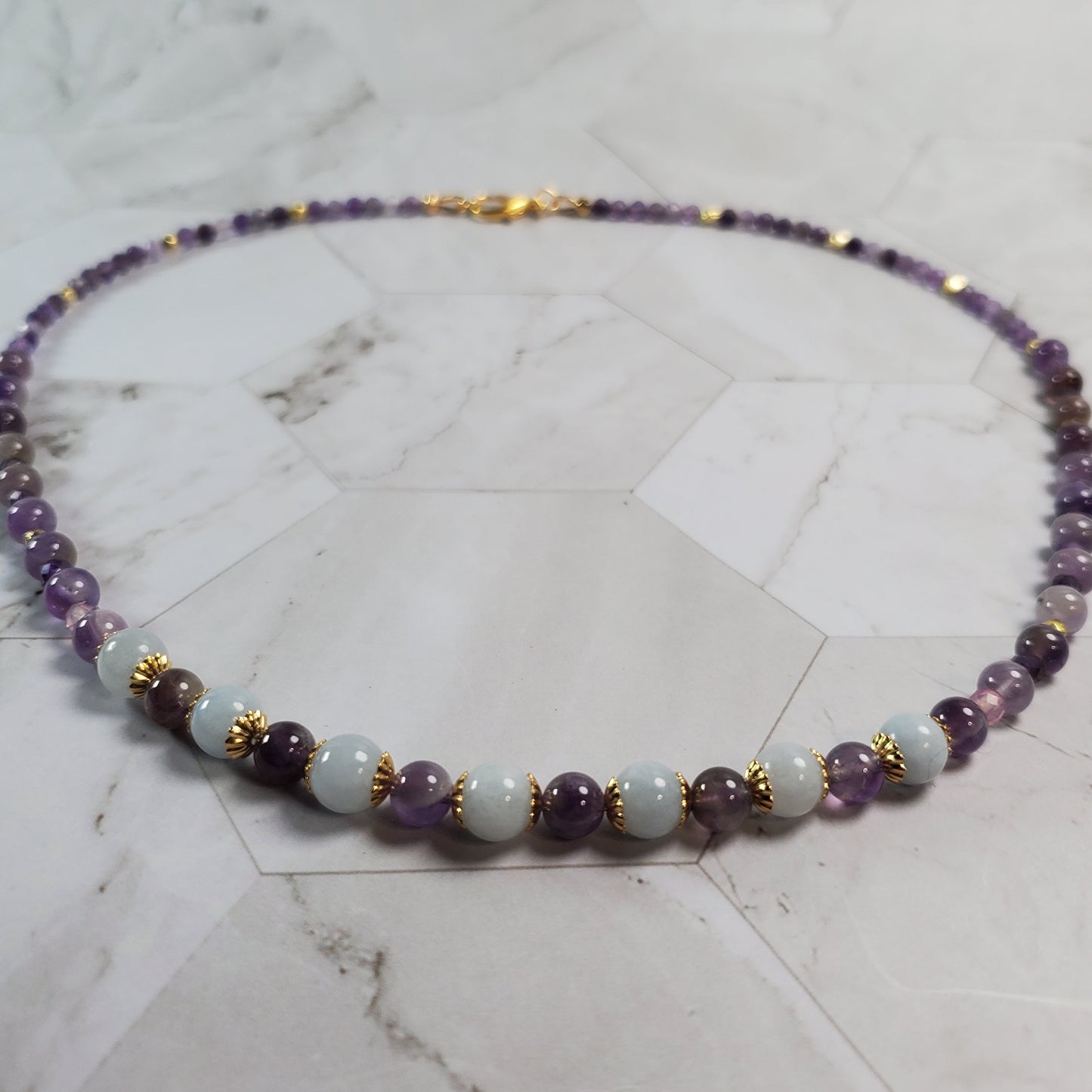 Necklace with multicolored beads on a marble surface