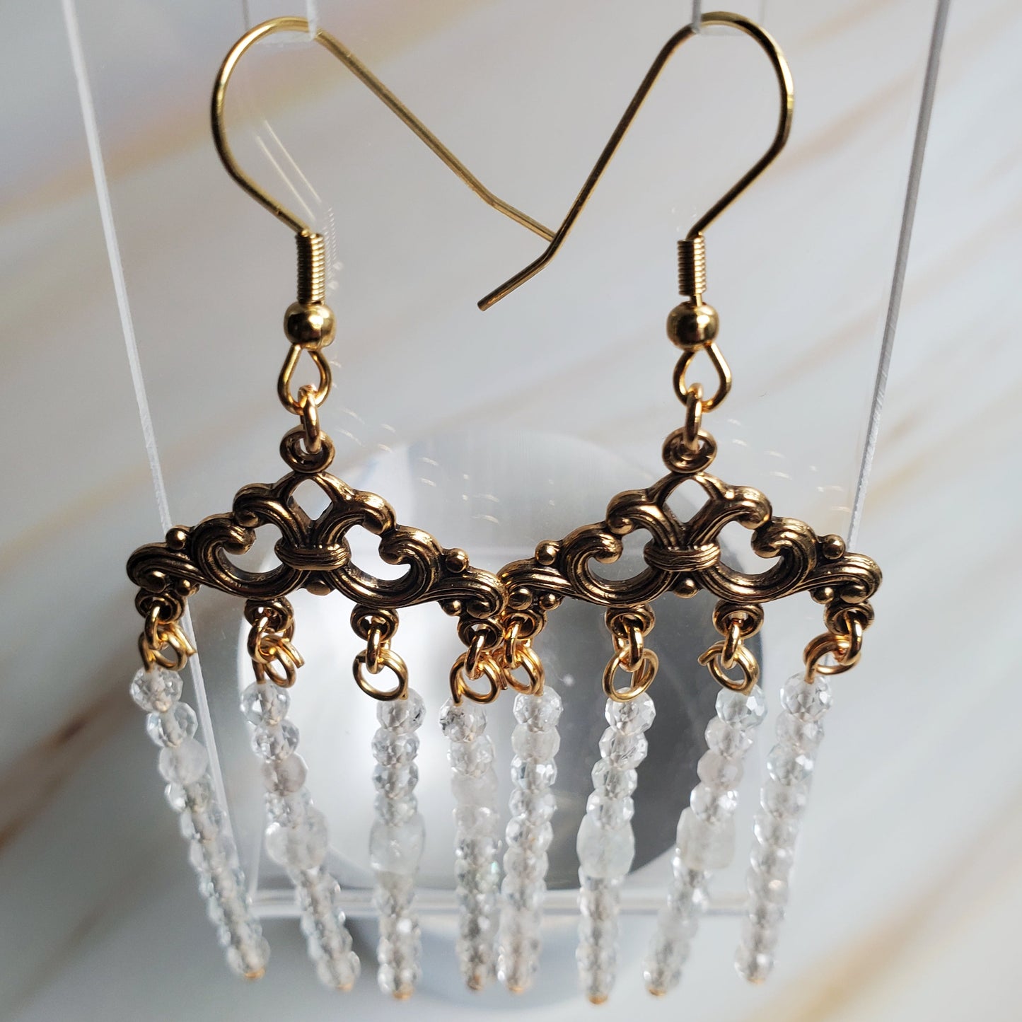 Gold and crystal earrings on a white background