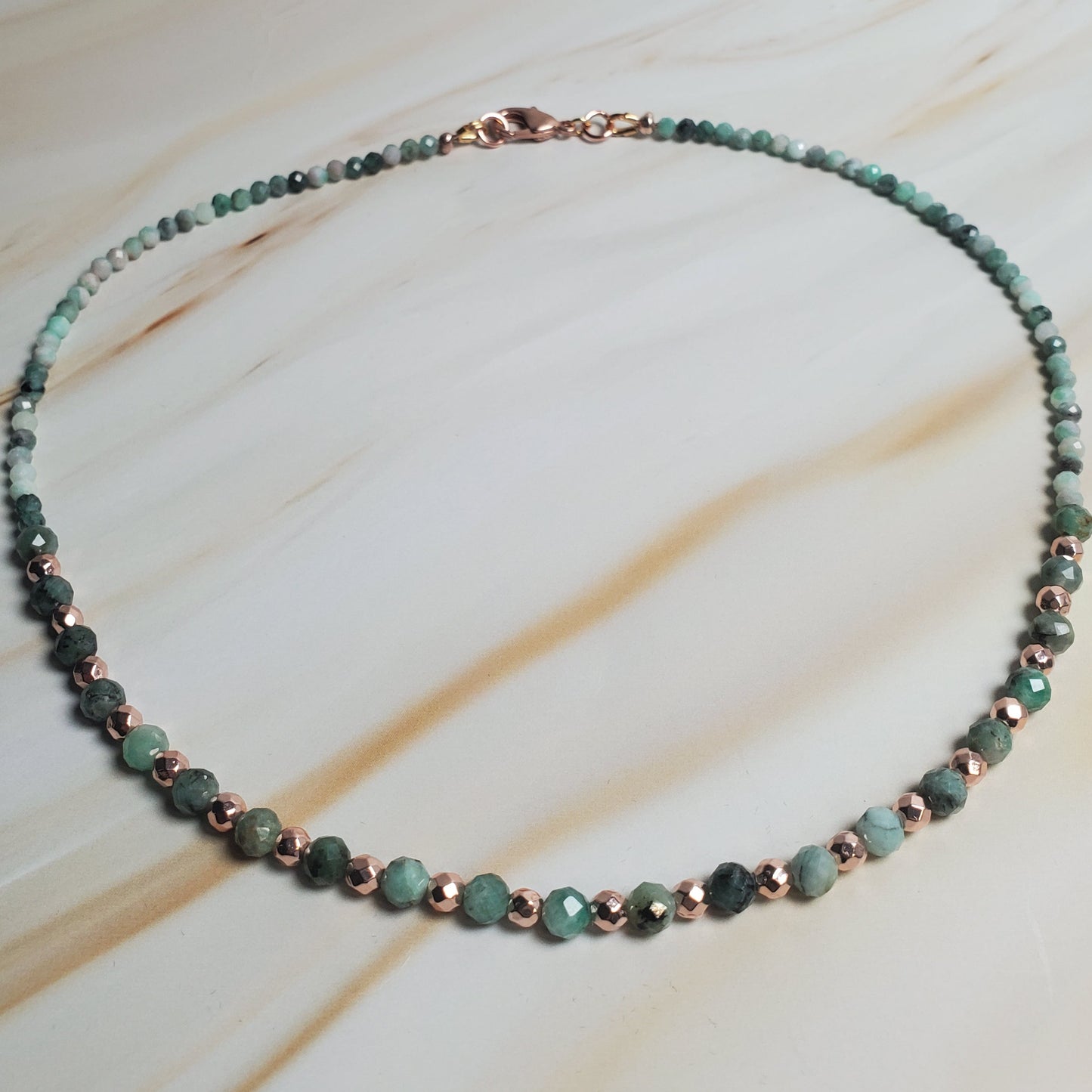 Necklace with green beads on a light wooden surface