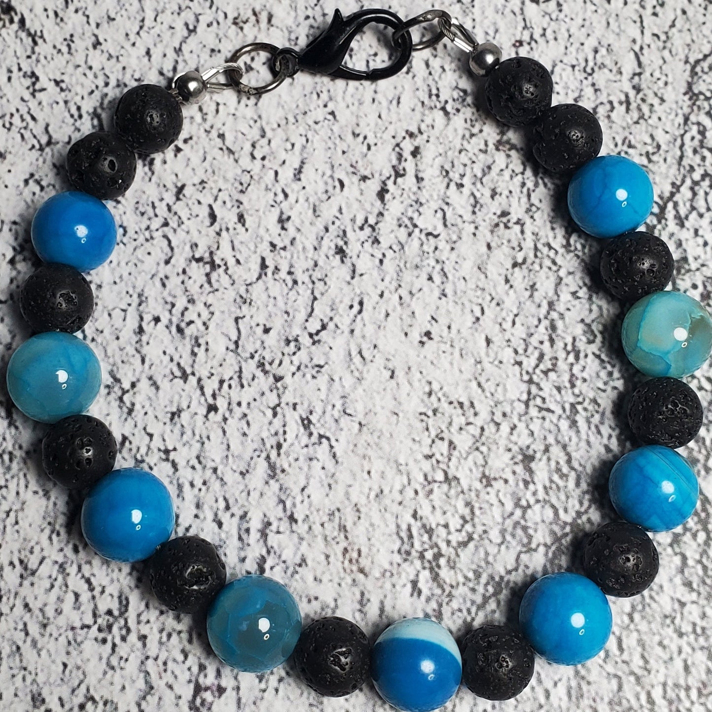 Bracelet with blue and black beads on a textured surface