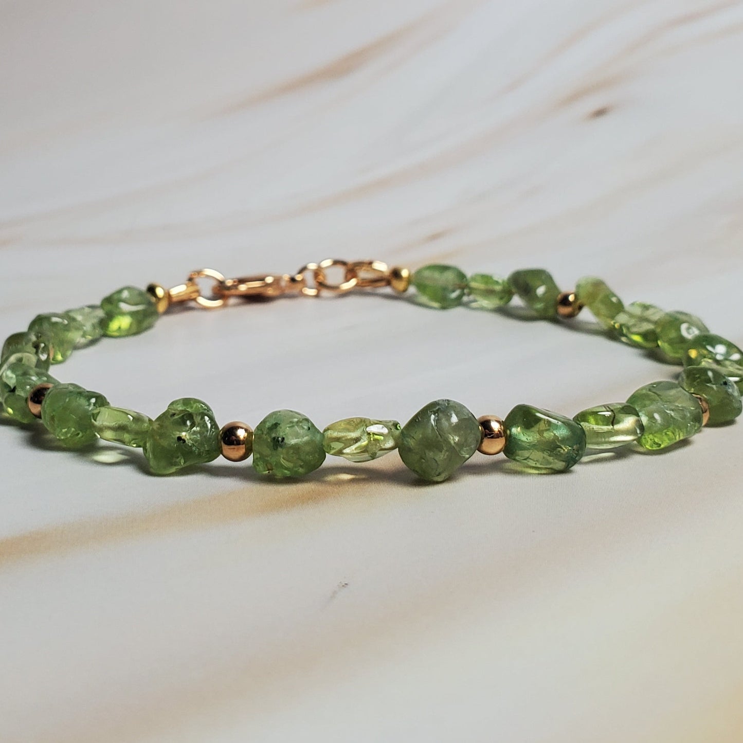 Green beaded bracelet on a marble surface