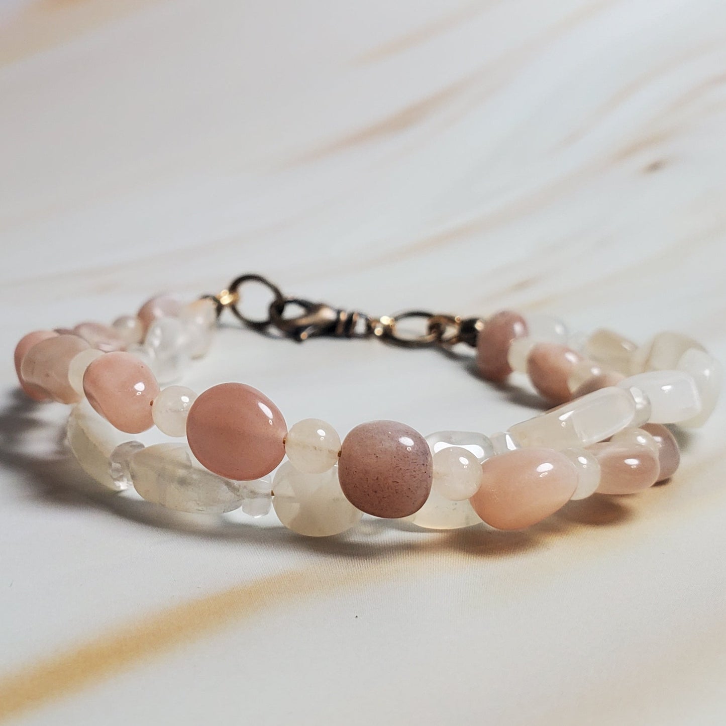 Bracelet with pink beads on a light wooden surface