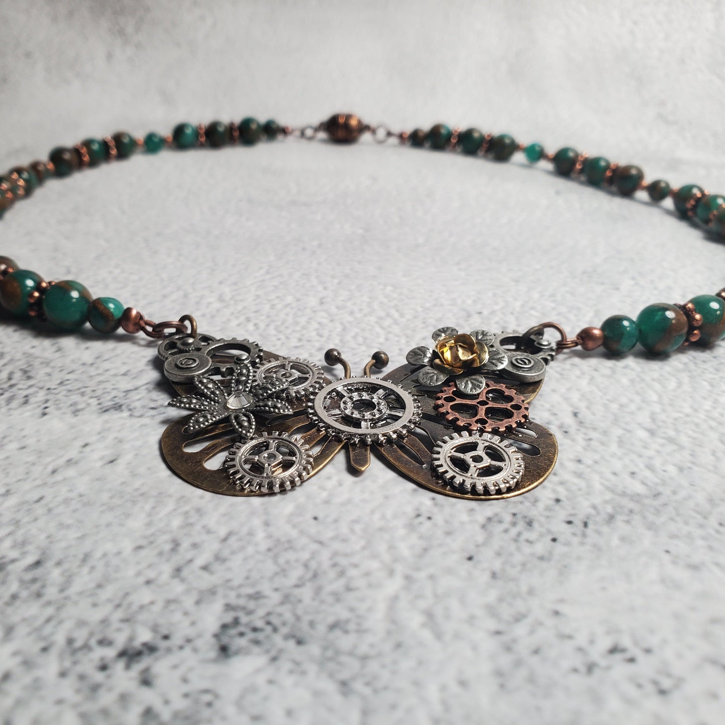 Handcrafted industrial style necklace with mechanical butterfly pendant, green resin beads, and copper accents