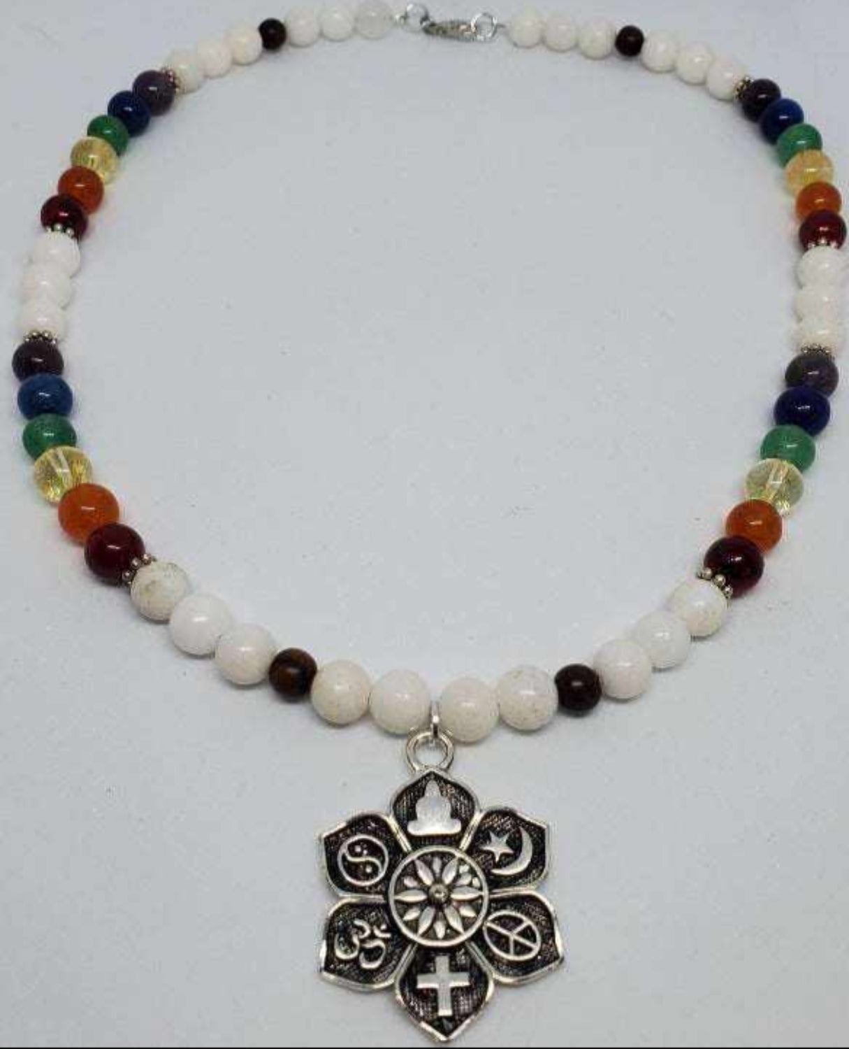 Handcrafted gemstone necklace with multicolored beads and pewter coexist pendant for unity and mindfulness.