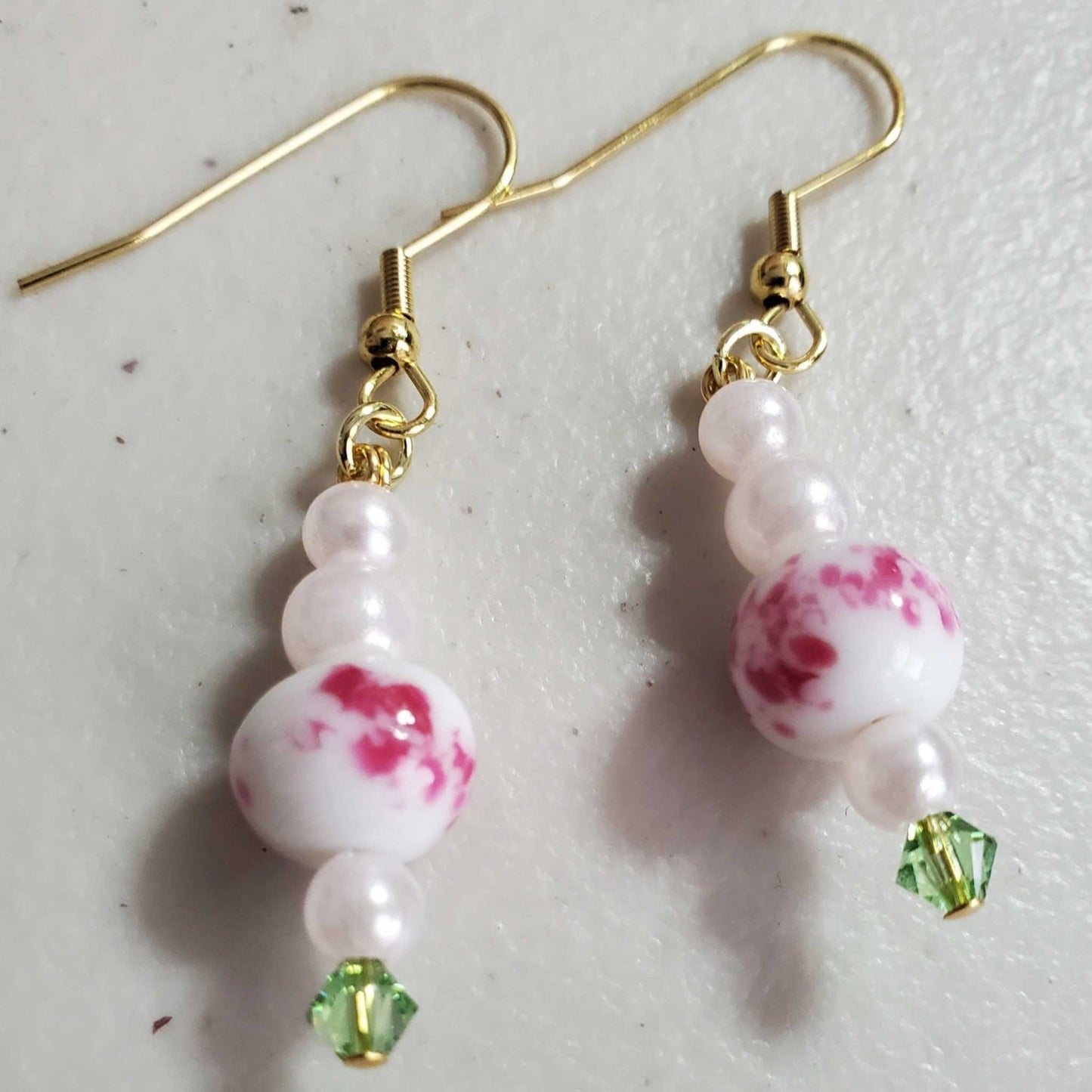 Vintage floral earrings with pink porcelain beads, acrylic pearls, and green crystal drops on gold hooks
