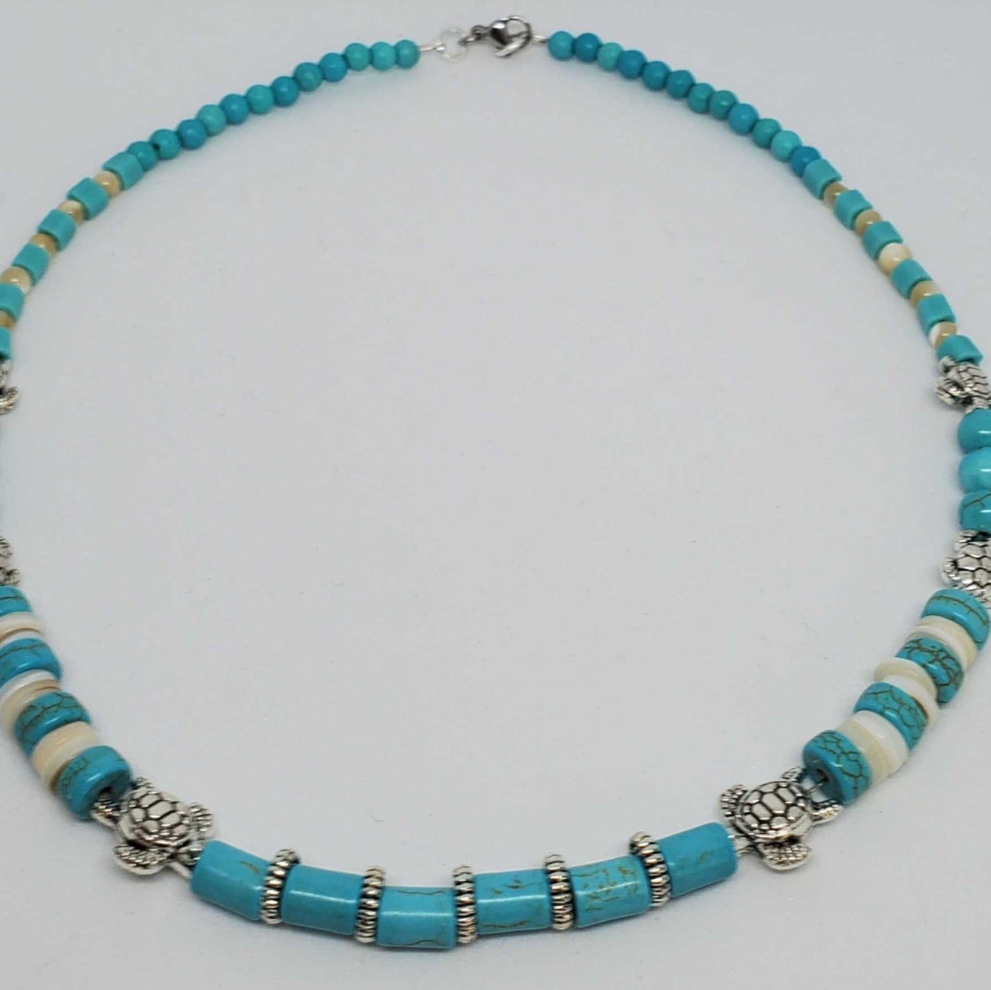 Southwestern style gemstone necklace with turquoise howlite, mother of pearl, turquoise magnesite, and pewter turtle beads
