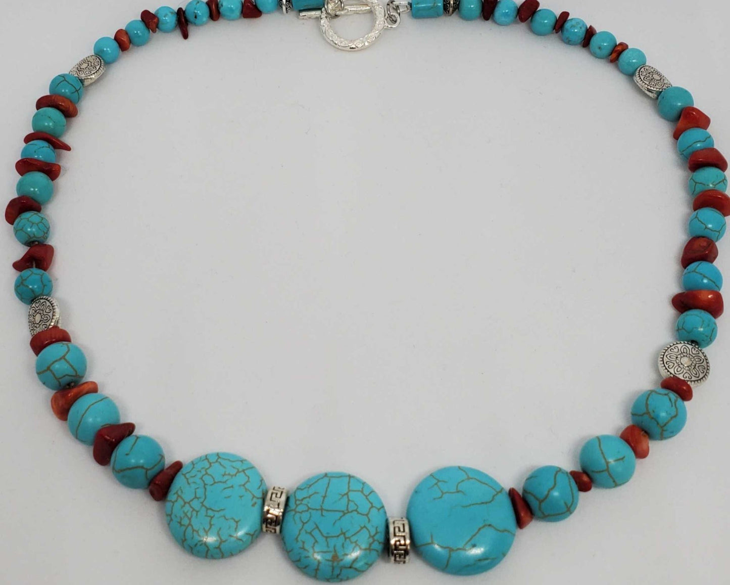 Southwestern style gemstone necklace with turquoise howlite, coral chips, and pewter spacers, 16-inch length with silver-tone toggle clasp.