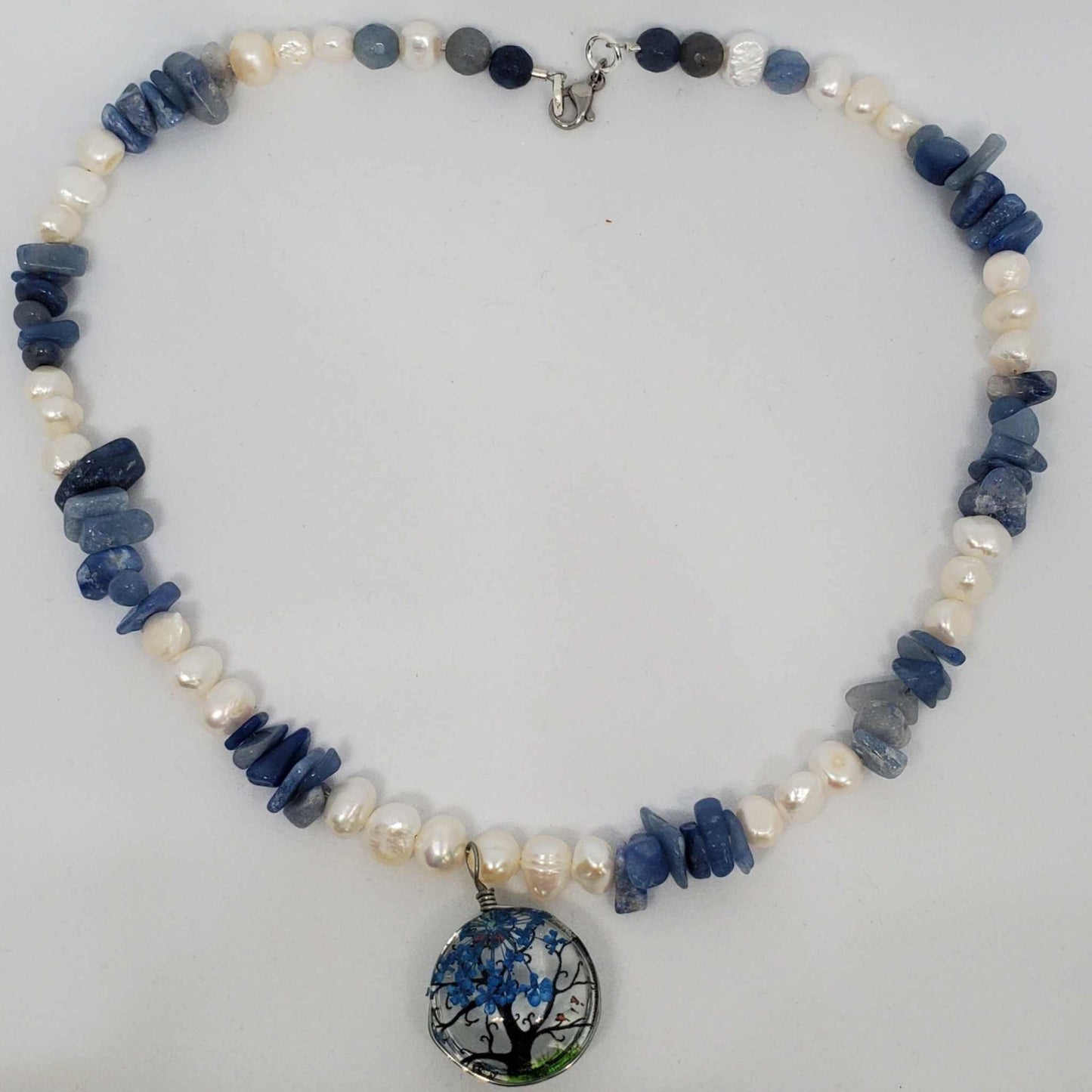 Gemstone necklace with blue chip beads, freshwater pearls, and double-sided acrylic tree pendant