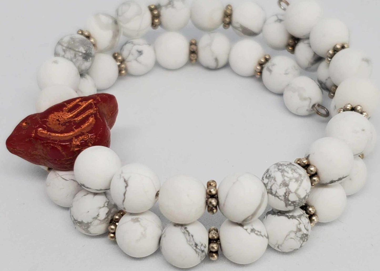 Adjustable gemstone bracelet with white Howlite beads and a red Czech glass bird bead