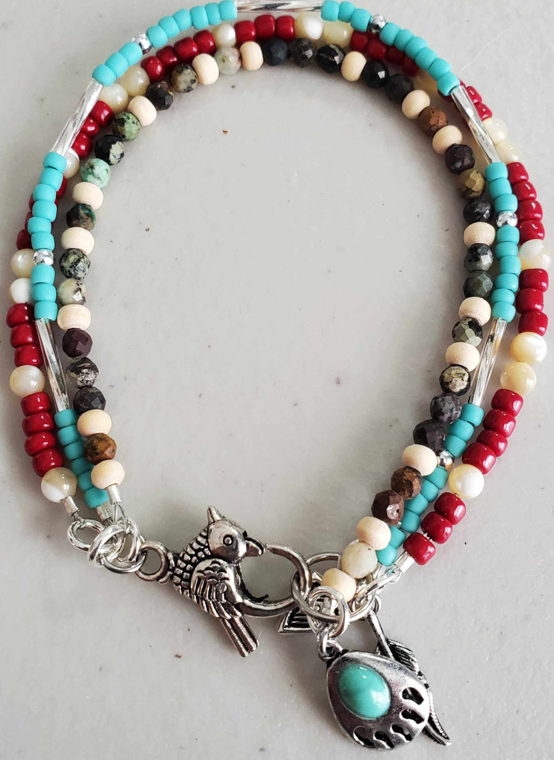 Southwestern triple strand charm bracelet with turquoise, mother of pearl, wood beads and pewter bird clasp