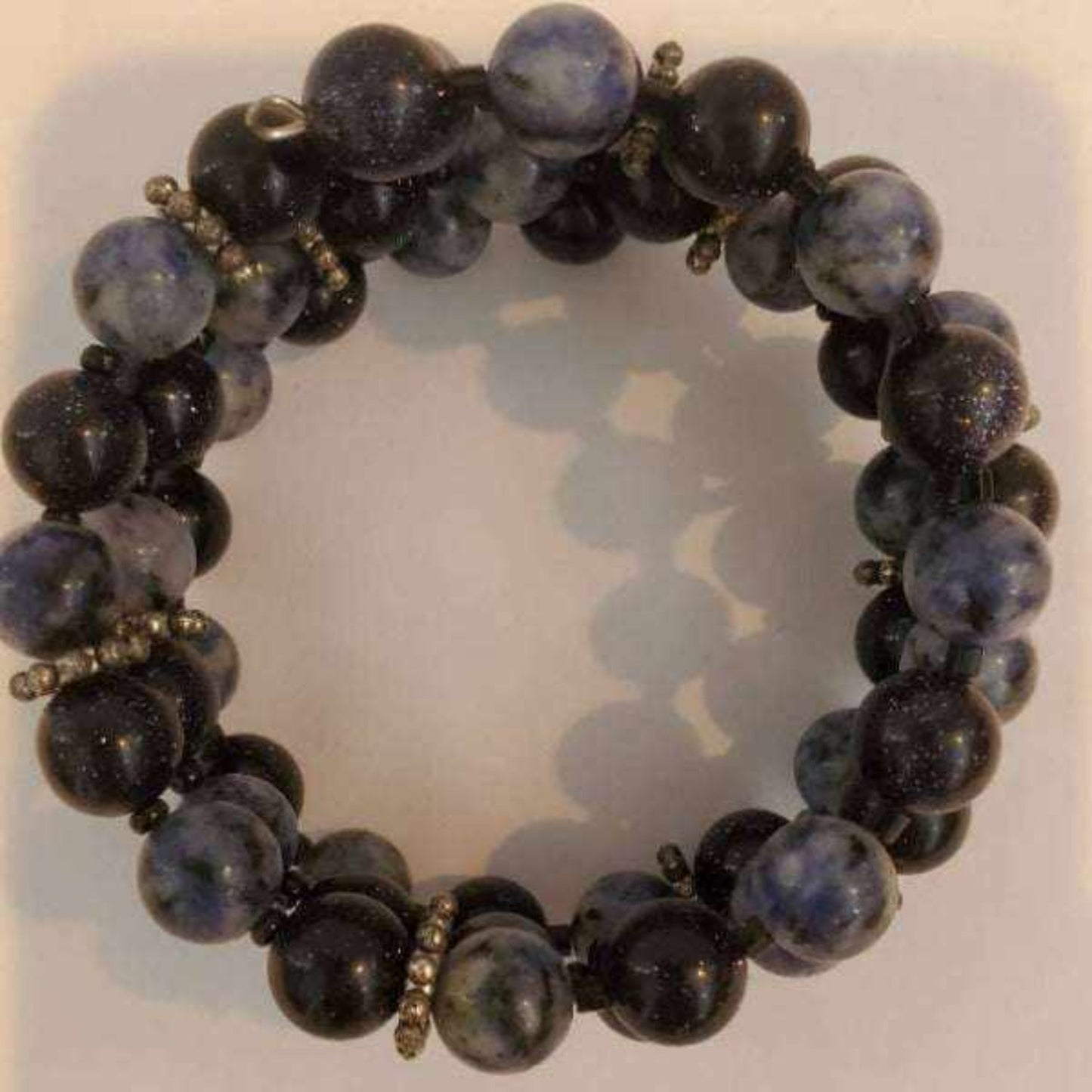 Gemstone bracelet with denim blue sodalite and blue goldstone beads on a flexible memory wire cuff