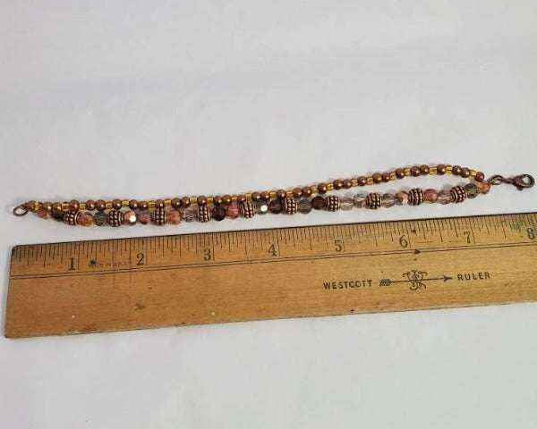 Handmade copper bracelet with Swarovski crystals and Czech glass beads alongside wooden ruler measuring 8 inches